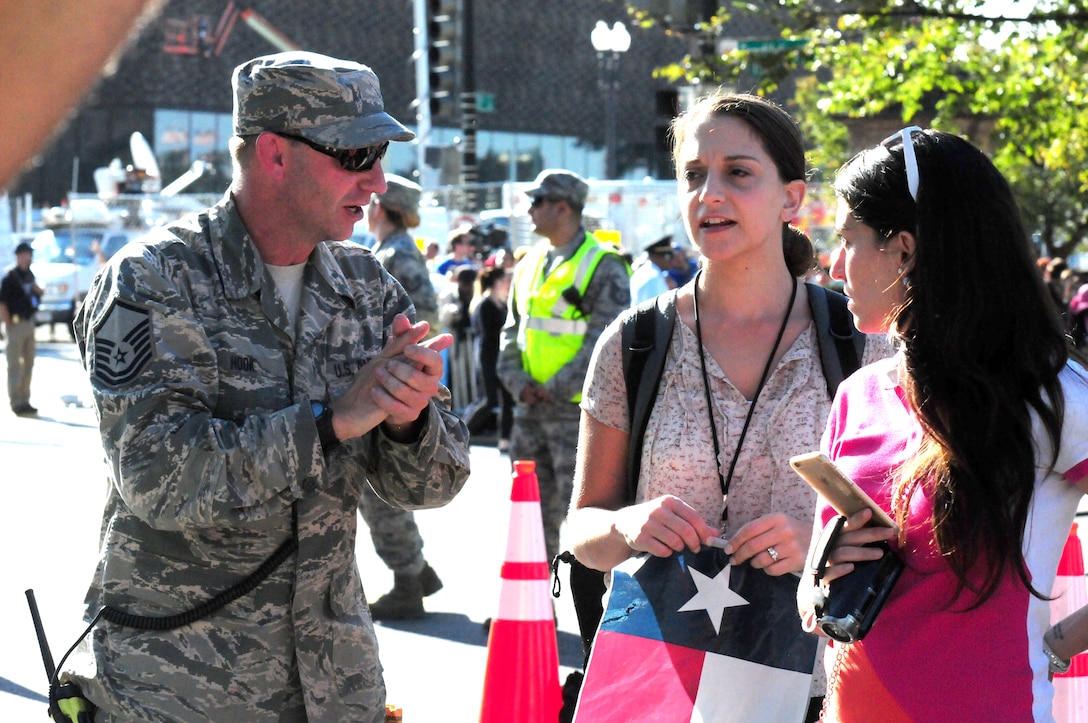 Master Sgt. Robert Hook, 113th Wing, D.C. Air National Guard, gives directions to an attendee at the 2015 Papal Visit in Washington, D.C., Sept. 23. Hook is one of more than 150 DCANG Airmen supporting Operation Roman Watch as crowd control and traffic management. (U.S. Air National Guard photo by Senior Airman Erica Rodriguez)