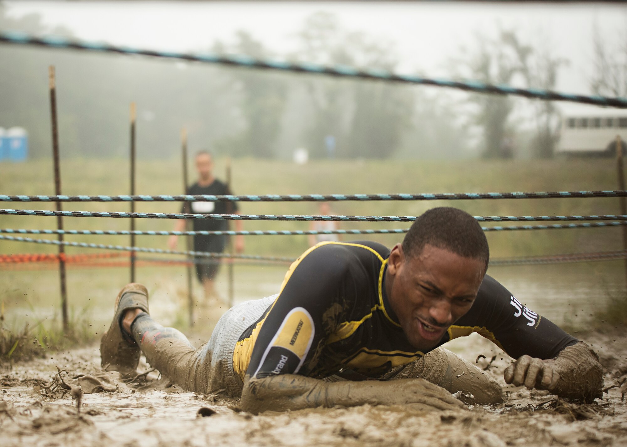 A runner crawls through mud during the 2015 “Beast of the East” Mud Run held Sept. 19, 2015 at Joint Base McGuire-Dix-Lakehurst, New Jersey. Runners had to crawl, swim, jump and climb over 20 obstacles along the course which included several mud pits and ponds; a tire flip; a ropes course; foam; climbing walls and many more. (U.S. Air Force photo by Staff Sgt. Katherine Tereyama)