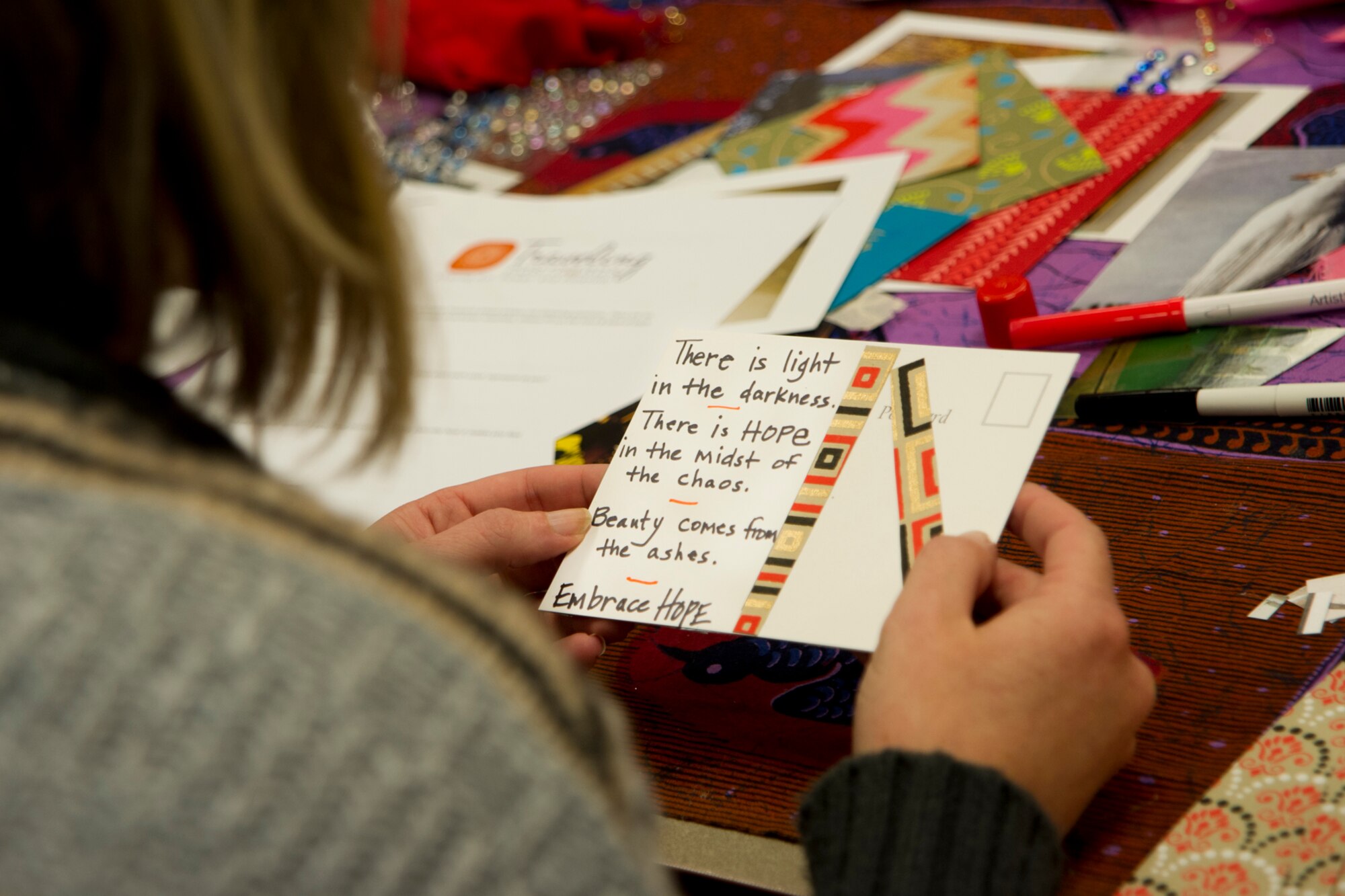 Emily Hays, a non-profit human services organization therapist, reads a message of empowerment she wrote on a handmade postcard during a healing arts workshop at Grissom Air Reserve Base, Ind., Sept. 22, 2015. More than 20 Grissom Airmen, local, state and national therapists created traveling postcards for survivors of domestic violence and sexual assault. (U.S. Air Force photo/Senior Airman Katrina Heikkinen) 