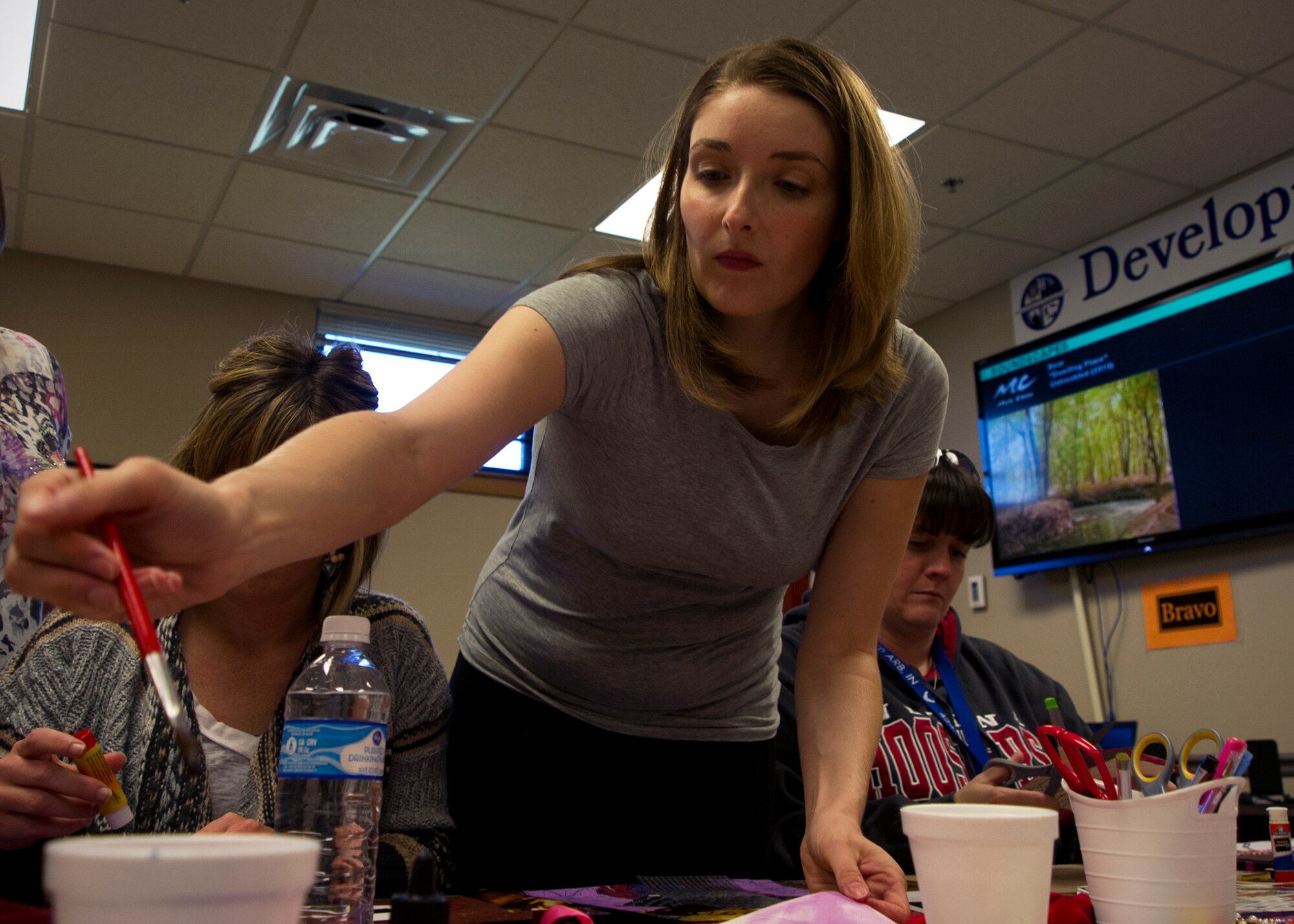 Lacey Rentschler-Miller, social worker, dips a paintbrush into water before painting a postcard during a healing arts workshop at Grissom Air Reserve Base, Ind., Sept. 22, 2015. In an effort to emphasize the Air Force’s commitment to eliminate sexual assault through victim advocacy and response, more than 20 Grissom Airmen, and local, state and national therapists attended the workshop to create postcards for survivors of domestic violence and sexual assault. (U.S. Air Force photo/Senior Airman Katrina Heikkinen) 