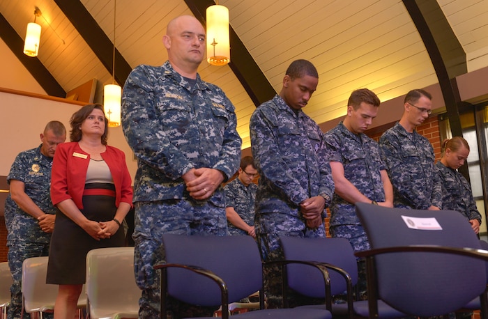 Bowing their heads, during the Navy Gold Star Remembrance ceremony both civilian and service members stand together at Good Shepherd Chapel Sept. 23, 2015 on Joint Base Charleston –Weapons Station, Charleston, S.C. The event honors local fallen Sailors.