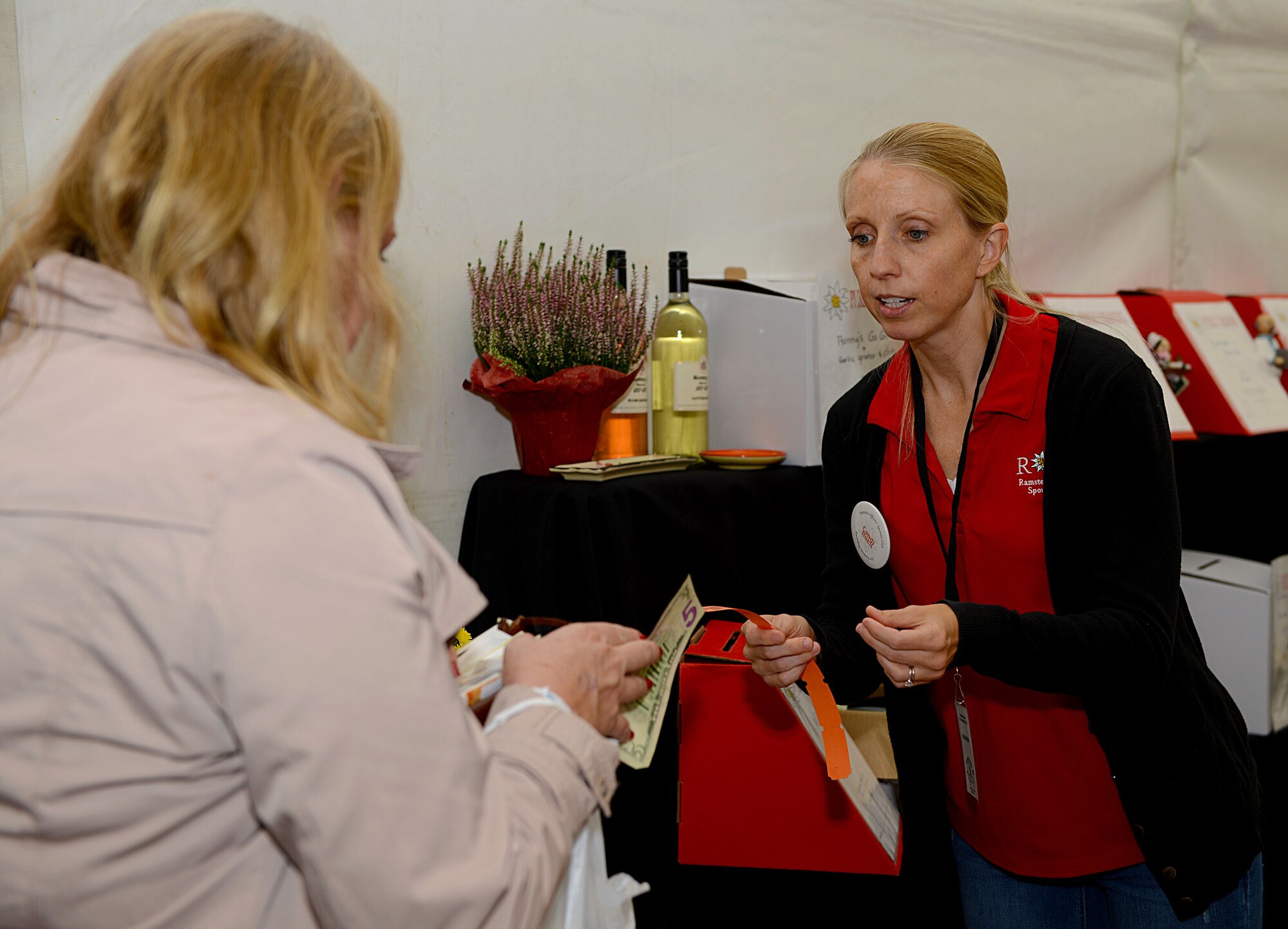 Candi Buell, Ramstein Officers’ Spouses Club member, sells raffle tickets for the gift drawing during the 51st Ramstein Bazaar Sept. 19, 2015, at Ramstein Air Base, Germany. The proceeds from the gift drawing are used for the ROSC’s Pay It Forward program, through which ROSC members purchase gift cards for the commissary, food items at the Kaiserslautern Military Community Center food court, or other free items for service members and families around base. (U.S. Air Force photo/Senior Airman Timothy Moore)
