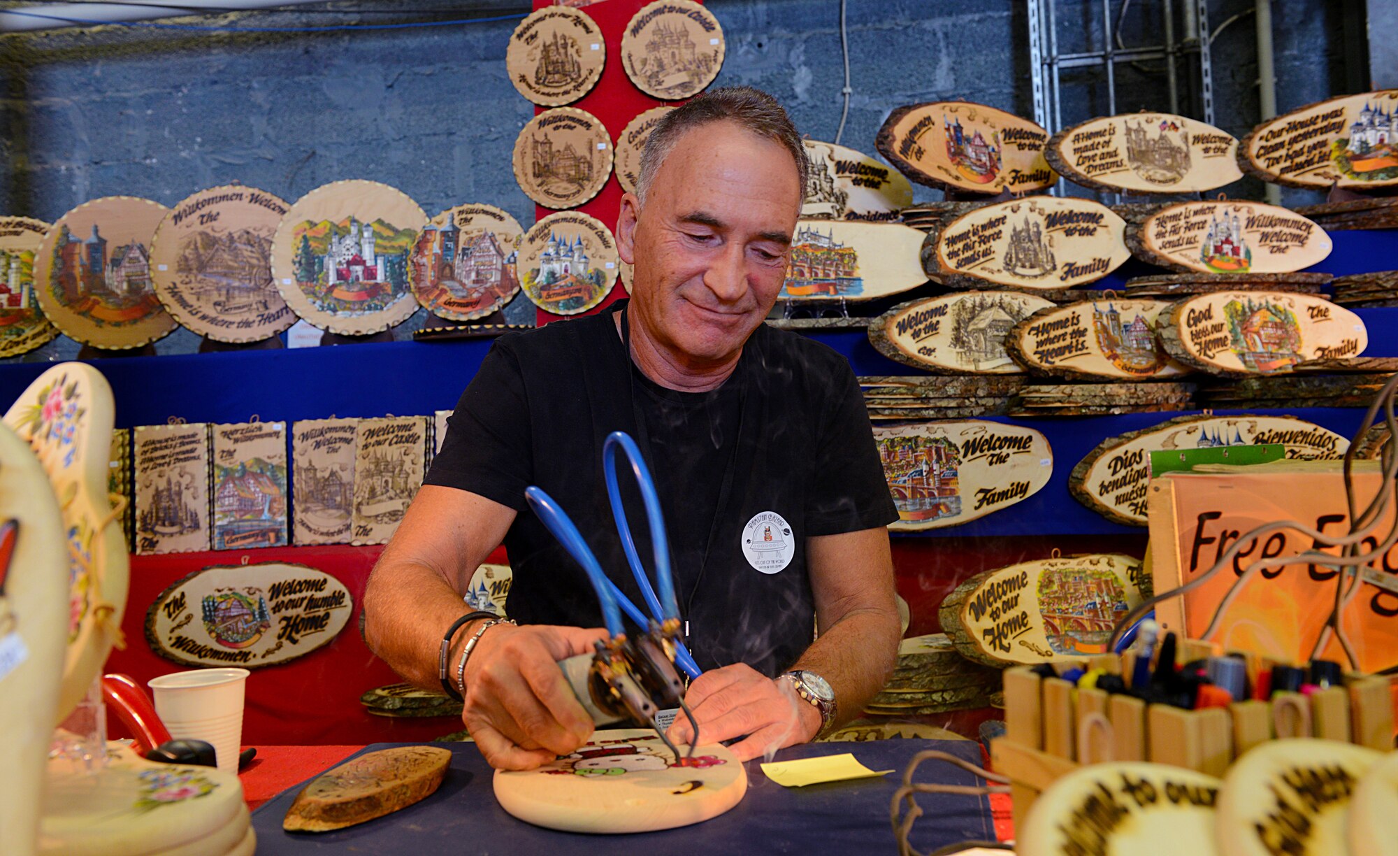 Martin Reimlinger engraves a piece of wood Sept. 19, 2015, at Ramstein Air Base, Germany. Reimlinger was one of many vendors present at the 51st Ramstein Bazaar to showcase his merchandise. (U.S. Air Force photo/Senior Airman Timothy Moore)