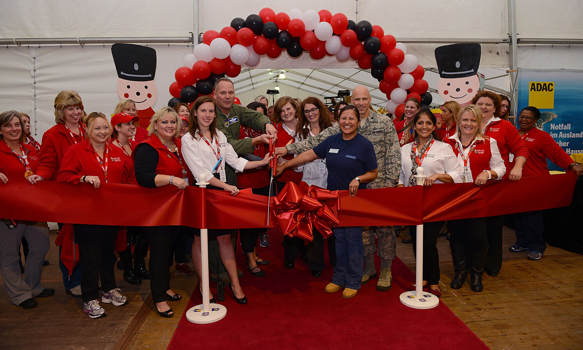 Brig. Gen. Jon T. Thomas, 86th Airlift Wing commander, cuts a ribbon with Lt. Col. Thomas Ausherman, 86th Force Support Squadron commander, and members of the Ramstein Bazaar committee and Ramstein Officers’ Spouses Club Sept. 16, 2015, at Ramstein Air Base, Germany. The ribbon-cutting ceremony officially opened the 51st Annual Ramstein Bazaar. (U.S. Air Force photo/Senior Airman Timothy Moore)