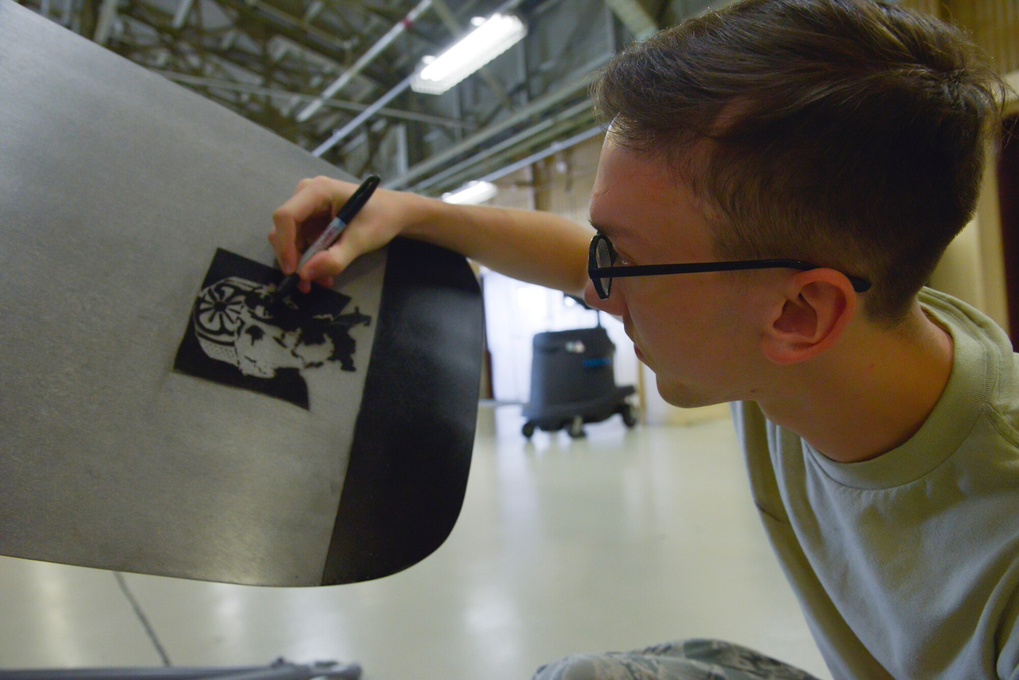 Airman 1st Class Kyle Cazier, 374th Maintenance Squadron propulsion flight aerospace propulsion apprentice, darkens part of a ‘Mr. Miyagi’ drawing on a propeller blade at Yokota Air Base, Japan, Sept. 23, 2015. The drawing is a reference point on the number three blade to ensure the number one blade is kept pointing up, preventing hydraulic fluid leaks. (U.S. Air Force photo by Senior Airman David Owsianka/Released)