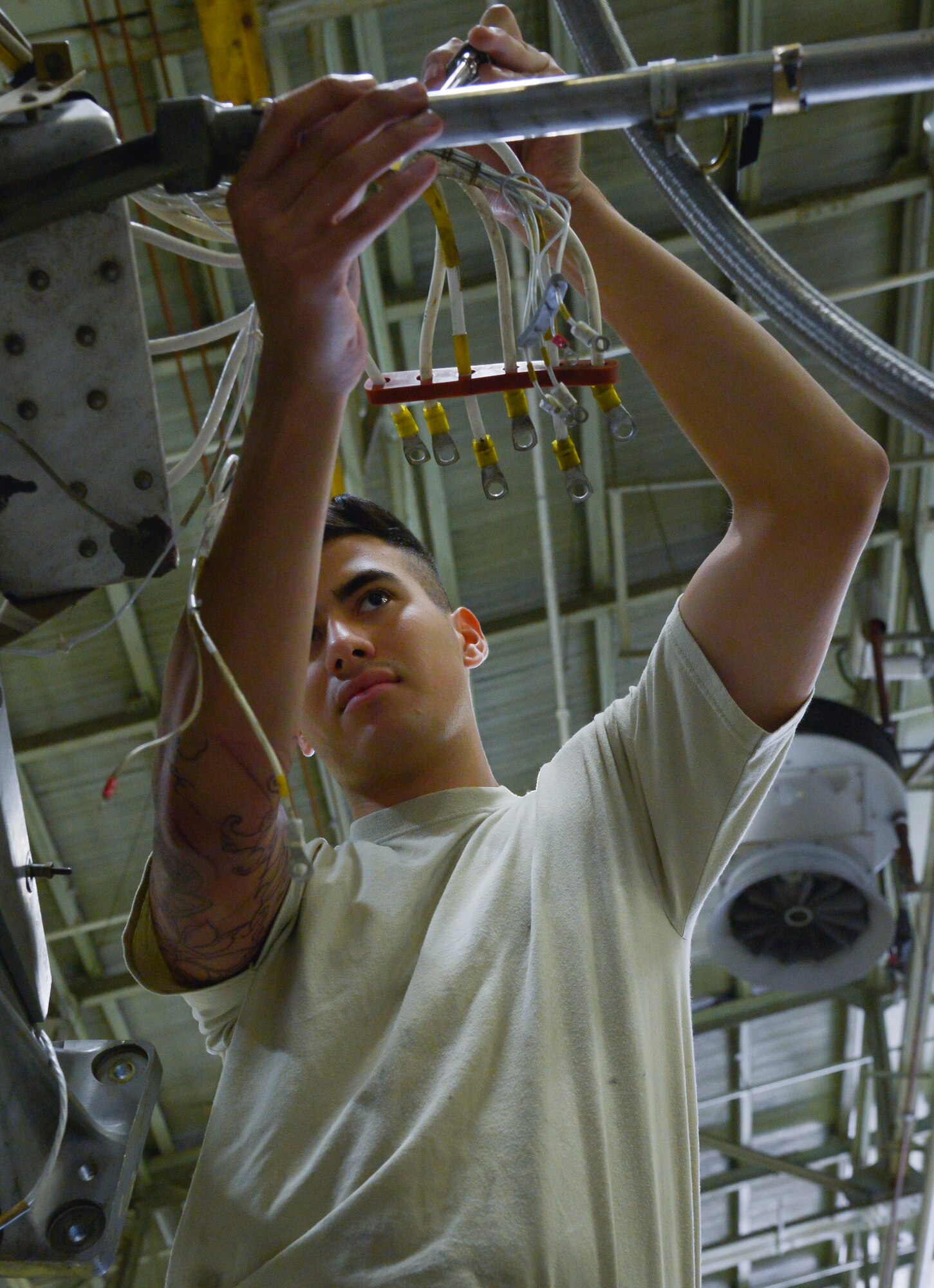 Airman 1st Class Gage Walker, 374th Maintenance Squadron propulsion flight aerospace propulsion apprentice, routes a generator harness on a quick engine change kit at Yokota Air Base, Japan, Sept. 23, 2015. The flight provides engines and propellers for the C-130 Hercules to make sure the aircraft can fly to perform airlift and humanitarian missions throughout the Indo-Asia Pacific Region. (U.S. Air Force photo by Senior Airman David Owsianka/Released)