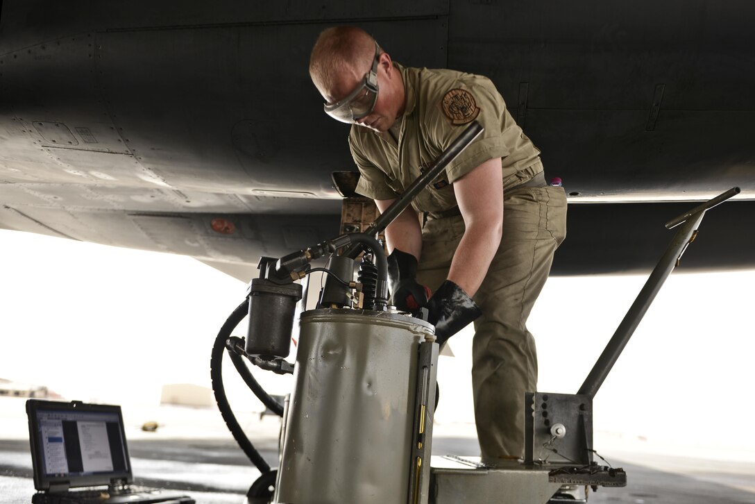 Airman 1st Class James Balcom, 37th Aircraft Maintenance Unit crew chief, fills the auxiliary power unit of a B1-B Lancer as part of his final inspections to ready the aircraft before an aircrew boards for a mission September 22, 2015 at Al Udeid Air Base, Qatar. Balcom is deployed from Ellsworth Air Force Base, S.D. (U.S. Air Force photo/Staff Sgt. Alexandre Montes)  