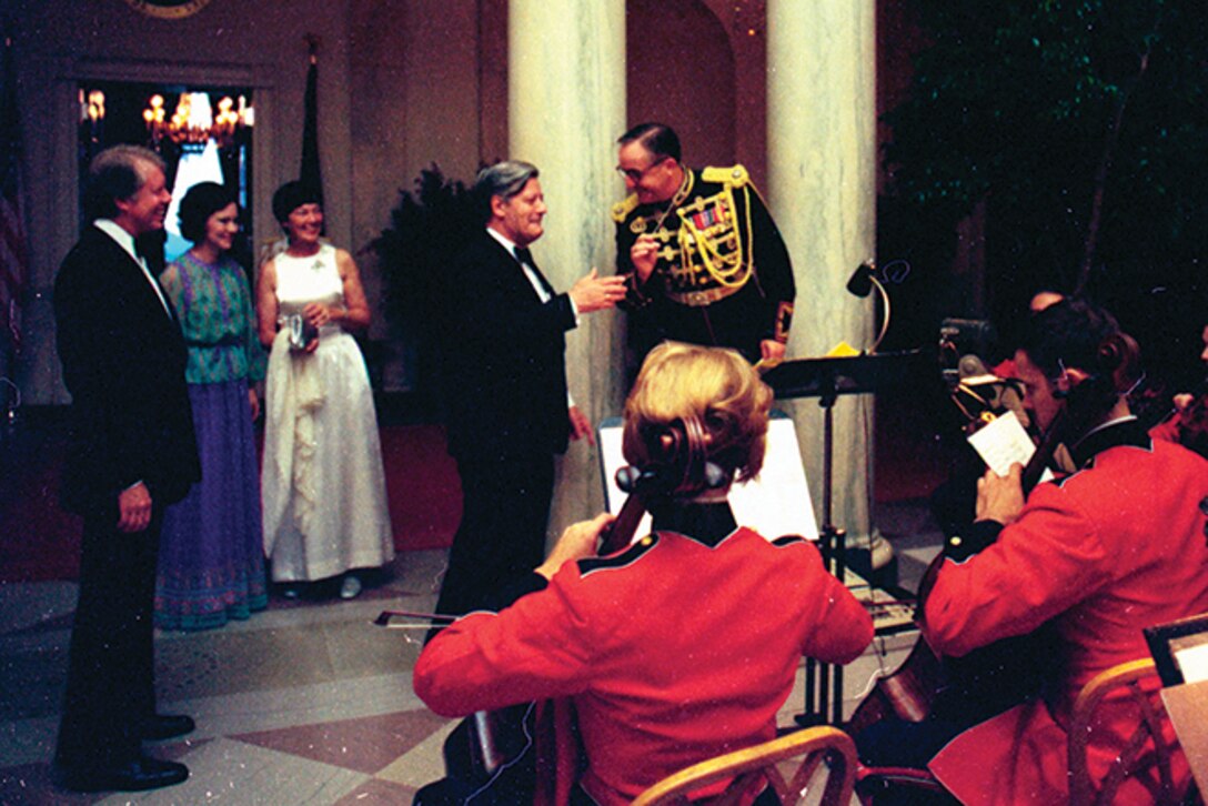 During a State Dinner on July 13, 1977, Marine Band Director Lt. Col. Jack Kline handed the baton to West German Chancellor Helmut Schmidt as President Jimmy Carter looks on. Photo courtesy of the Jimmy Carter Presidential Library.