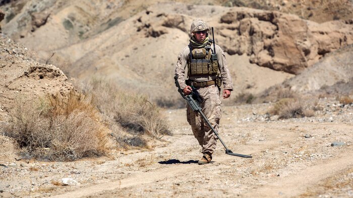 Staff Sgt. Joshua K. Crabtree, explosive ordnance disposal technician, 3rd EOD, 9th Engineer Support Battalion, performs a sweep with a metal detector during a post-blast analysis training scenario at Emerson Lake training area, Sept. 19, 2015. While aboard the Combat Center, EOD technicians received experience in working with a wider variety of ordnance than is usually available to the unit.