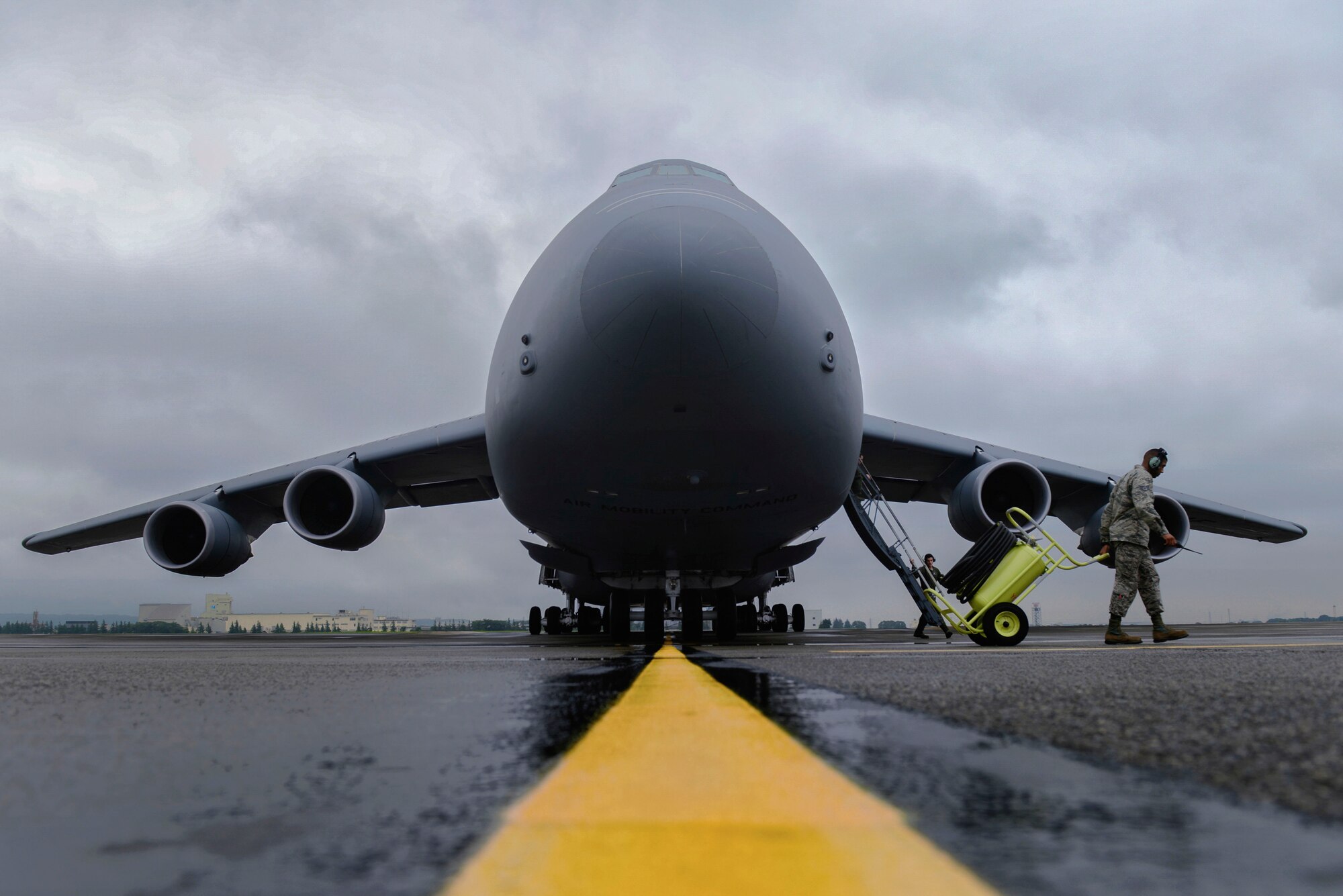 Staff Sgt. Randall Ard, 730th Air Mobility Squadron crew chief, clears the runway for a C-5 Galaxy at Yokota Air Base, Japan, Aug. 31, 2015. The 730th AMS provides maintenance support to four types of aircraft, including the world’s largest U.S. military aircraft, the C-5. (U.S. Air Force photo by Airman 1st Class Elizabeth Baker/Released)