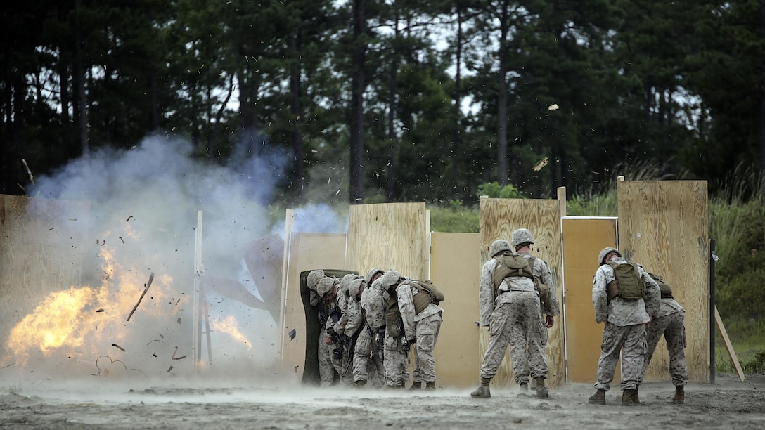 Marines with 2nd Battalion, 2nd Marine Regiment take cover behind a shielding blanket as an urban charge detonates during a demolitions exercise with 2nd Combat Engineer Battalion at Engineer Training Area  7 on Marine Corps Base Camp Lejeune, N.C., Sept. 22, 2015. Marines with 2/2 increased their proficiency and knowledge with various charges and techniques with the help of 2nd CEB. 