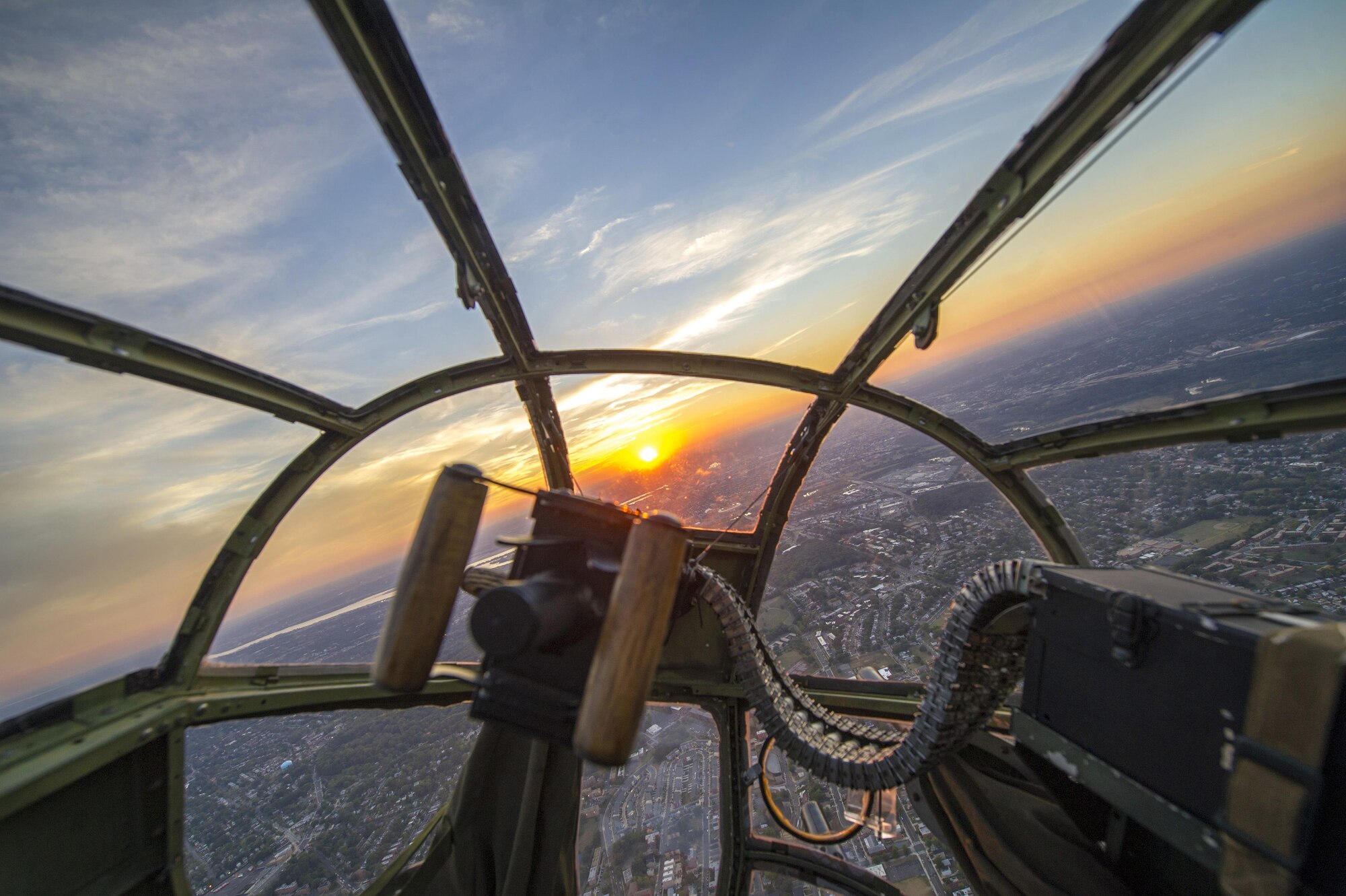 A sunset is seen through the nose of a B-25 Mitchell during a military tattoo held at Joint Base Anacostia-Bolling in Washington, Sept. 16, 2015. The “warbird flight” consisted of two B-25 Mitchells, two P-40 Warhawks and a P-51 Mustang. (U.S. Air Force photo/Airman 1st Class Ryan J. Sonnier)