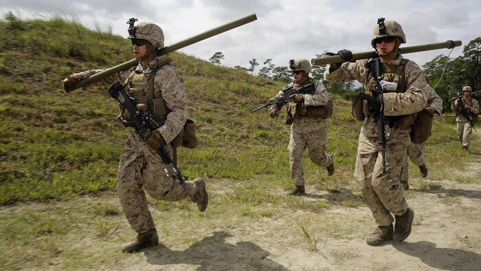 Marines with 2nd Battalion, 2nd Marine Regiment rush to a wire trap to set up a Bangalore charge to destroy the trap during a demolitions exercise with 2nd Combat Engineer Battalion at Engineer Training Area 7 on Marine Corps Base Camp Lejeune, N.C., Sept. 22, 2015. Marines with 2/2 increased their proficiency and knowledge with various charges and techniques with the help of 2nd CEB.