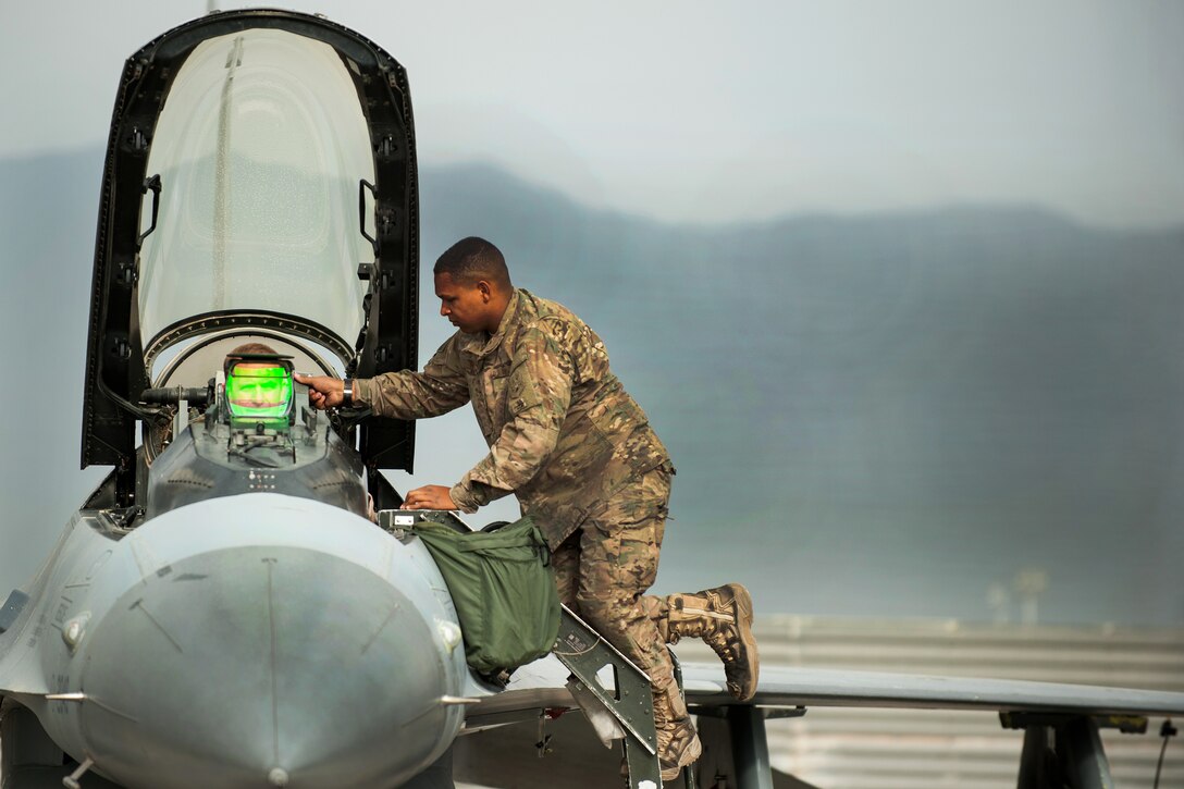 A U.S. airman assists an F-16 Fighting Falcon pilot before a combat sortie on Bagram Airfield, Afghanistan, Sept. 22, 2015. The airman is assigned to the 455th Expeditionary Maintenance Squadron and the pilot is assigned to the 555th Expeditionary Fighter Squadron. U.S. Air Force photo by Tech. Sgt. Joseph Swafford