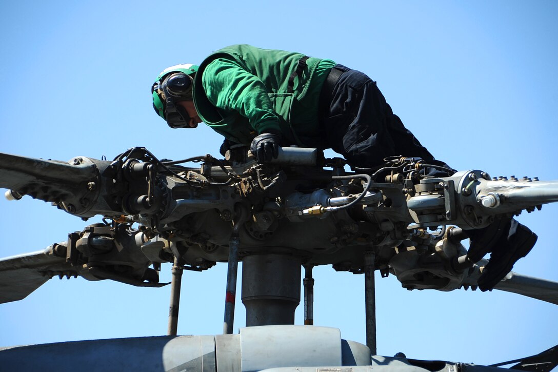U.S. Navy Petty Officer 3rd Class Jorge Delacerda does final checks on an HH-60H Seahawk helicopter on the flight deck aboard the aircraft carrier USS Theodore Roosevelt in the Arabian Gulf, Sept. 24, 2015. The carrier is supporting Operation Inherent Resolve, which includes strike operations in Iraq and Syria as directed. The Seahawk is assigned to Helicopter Anti-Submarine Squadron 11. U.S. Navy photo by Petty Officer 3rd Class Anna Van Nuys
