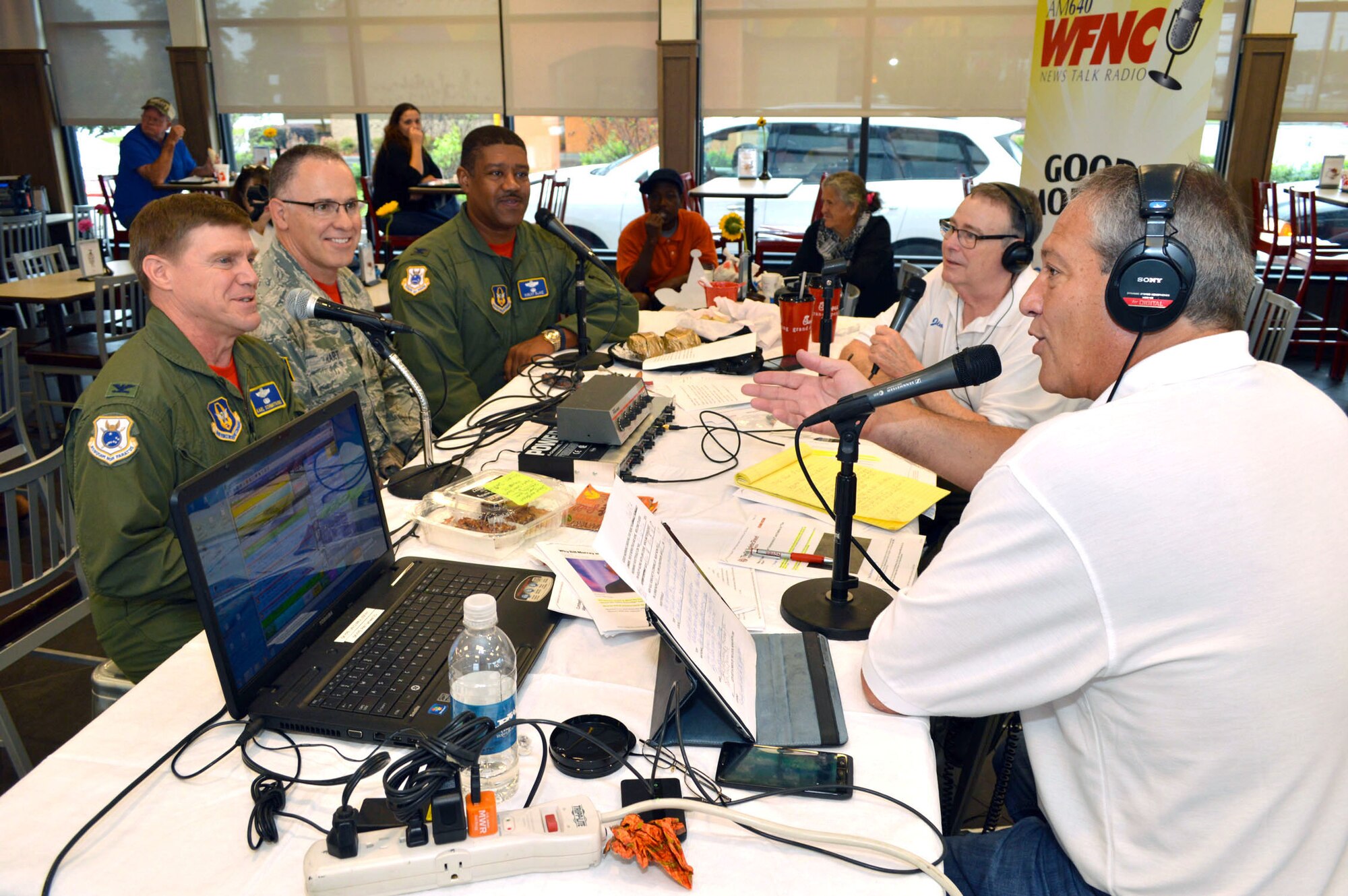 Col. Karl Schmitkons, 440th Airlift Wing commander, left, Command Chief Master Sgt. Rocky Hart, 440th AW command chief, middle, and Col. Robert Blake, 440th AW vice commander, right, join Jeff "Goldy" Goldberg and Jim Cooke of WFNC 640 AM radio for a live on-air interview celebrating the third anniversary of WFNC's 'Good Morning Fayetteville' radio show Sept. 25, 2015,at the Chick-fil-A on Skibo Road, Fayetteville, North Carolina. (U.S. Air Force photo/Marvin Krause)