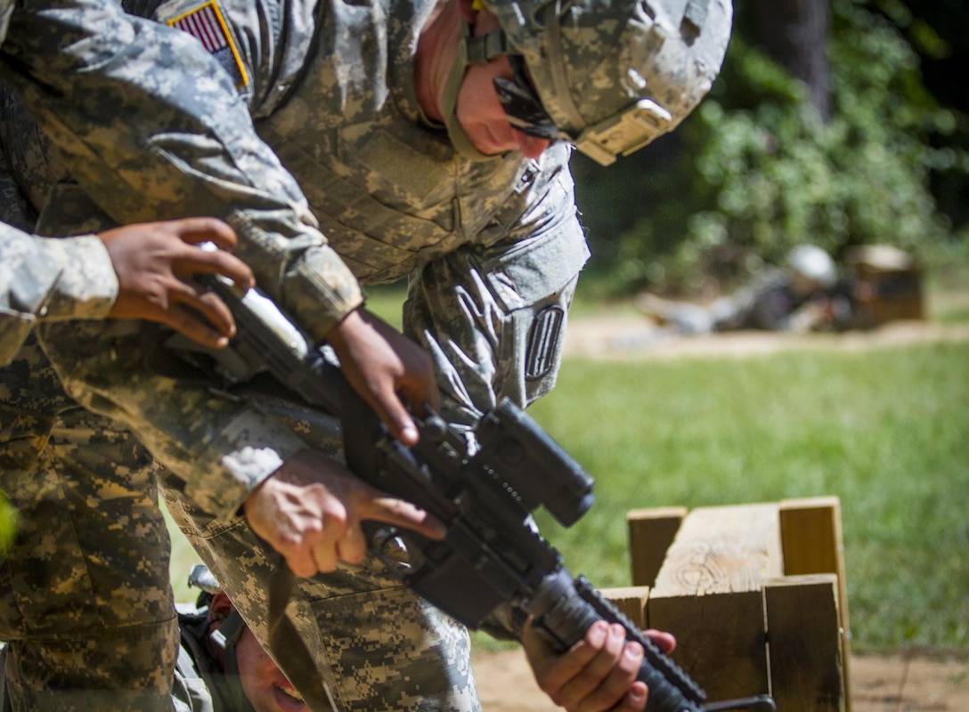 Army range cadres clear an M16 for a soldier who was moving through a live-fire buddy range when his weapon jammed during basic training at Fort Jackson, S.C., Sept. 19, 2015. U.S. Army photo by Sgt. Ken Scar