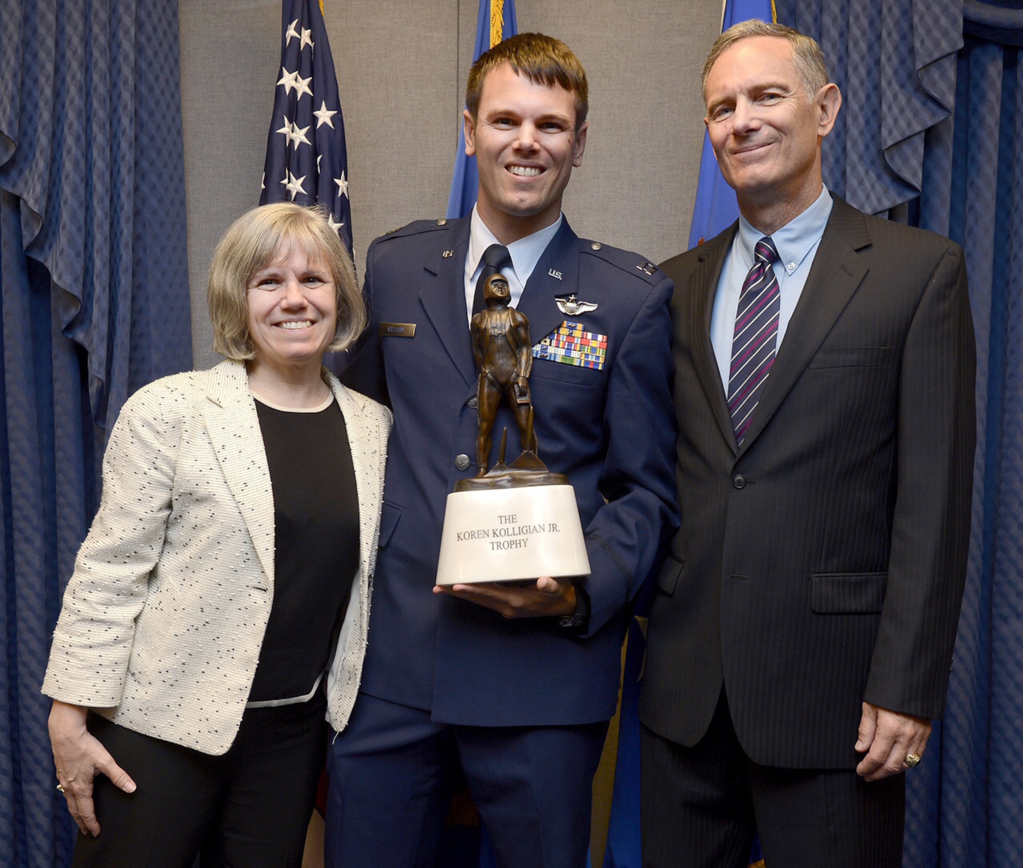 Capt. Timothy Killham, an F-35 Lightning II pilot from the 33rd Flying Training Squadron at Eglin Air Force Base, Fla., stands with his mother, Diane Kuknyo, and his father, retired Lt. Col. Michael Killham, after receiving the Koren Kolligian trophy during a Pentagon ceremony Sept. 23, 2015. The Kolligian Award recognizes outstanding airmanship by an aircrew member, and is named after 1st Lt. Koren Kolligian, who went missing while piloting his T-33 aircraft off the coast of California. (U.S. Air Force photo/Scott M. Ash)