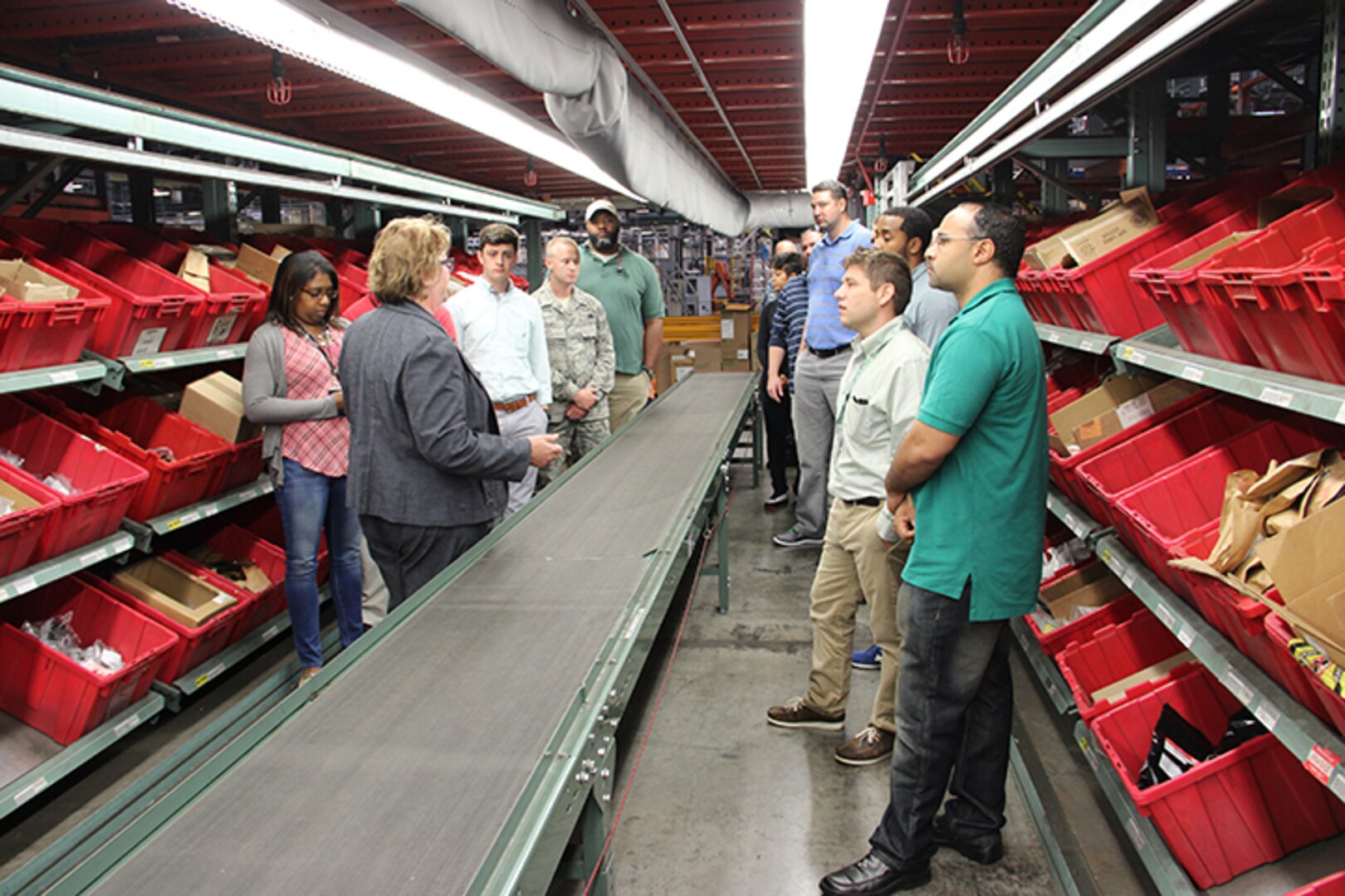 Sherre Mitten-Bell (left in gray), DLA Distribution Susquehanna public affairs officer, shows DLA Troop Support Industrial Hardware employees, the “pick and pack” area at the warehouse facility in New Cumberland, Pennsylvania during a visit Sept. 16. DLA IH employees visited the warehouse to get a better understanding of the process of getting material to the warfighter once the contract is awarded.