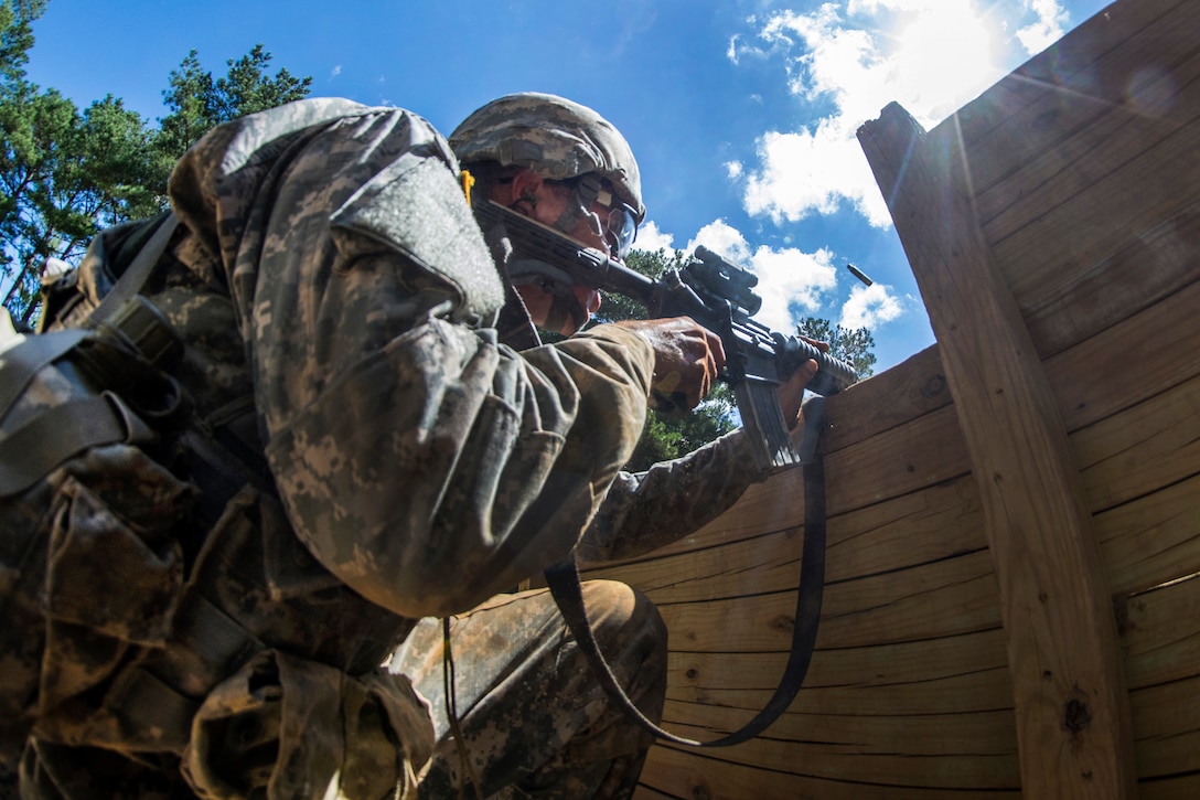 Army Pvt. Karlois Cesunas lays suppressing fire from behind a barrier to cover members of his team as they conduct a team live-fire during basic training on Fort Jackson, S.C., Sept. 19, 2015. U.S. Army photo by Sgt. Ken Scar