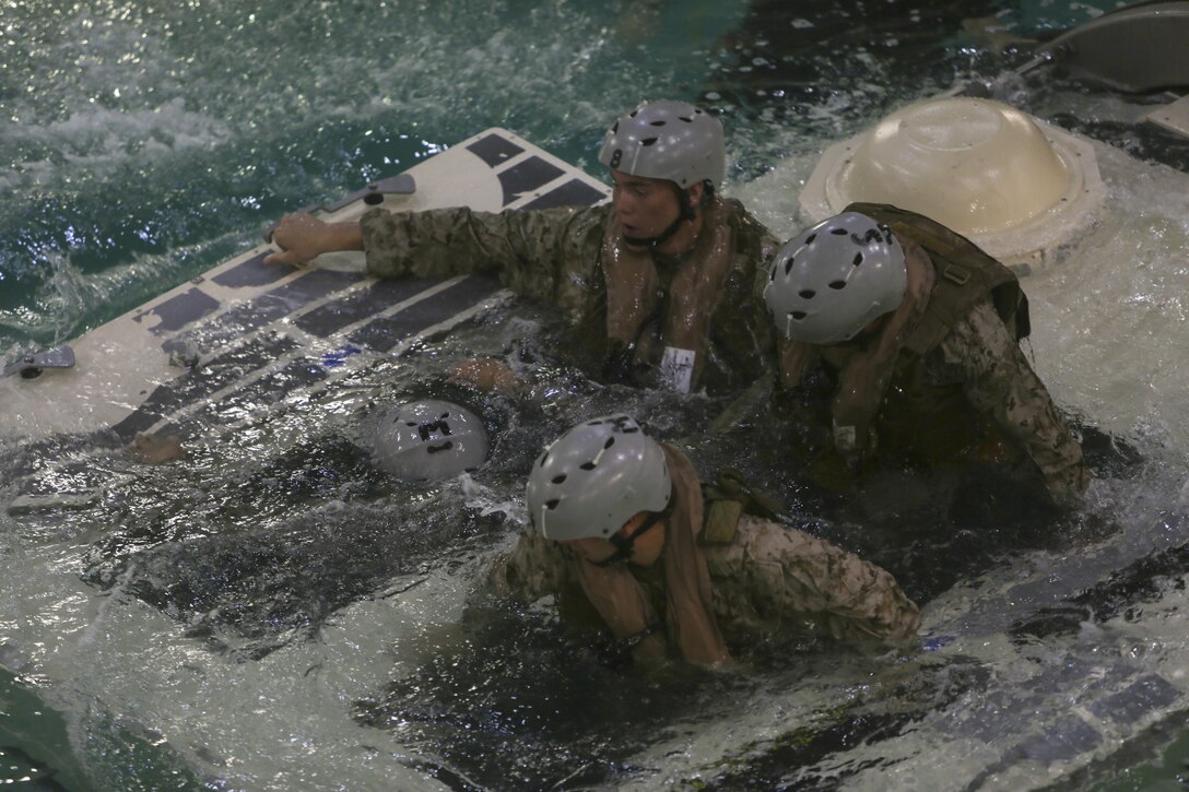 Marines with Echo Company, Battalion Landing Team, 2nd Battalion, 6th Marine Regiment, emerge from a simulated amphibious assault vehicle at Camp Lejeune, N.C., Sept. 22, 2015. The company participated in the submerged vehicle egress training in order to gain confidence in their abilities to safely exit a sinking amphibious assault vehicle in preparation for their upcoming deployment with the 26th Marine Expeditionary Unit. (U.S. Marine Corps photo by Cpl. Michelle Reif/Released.)