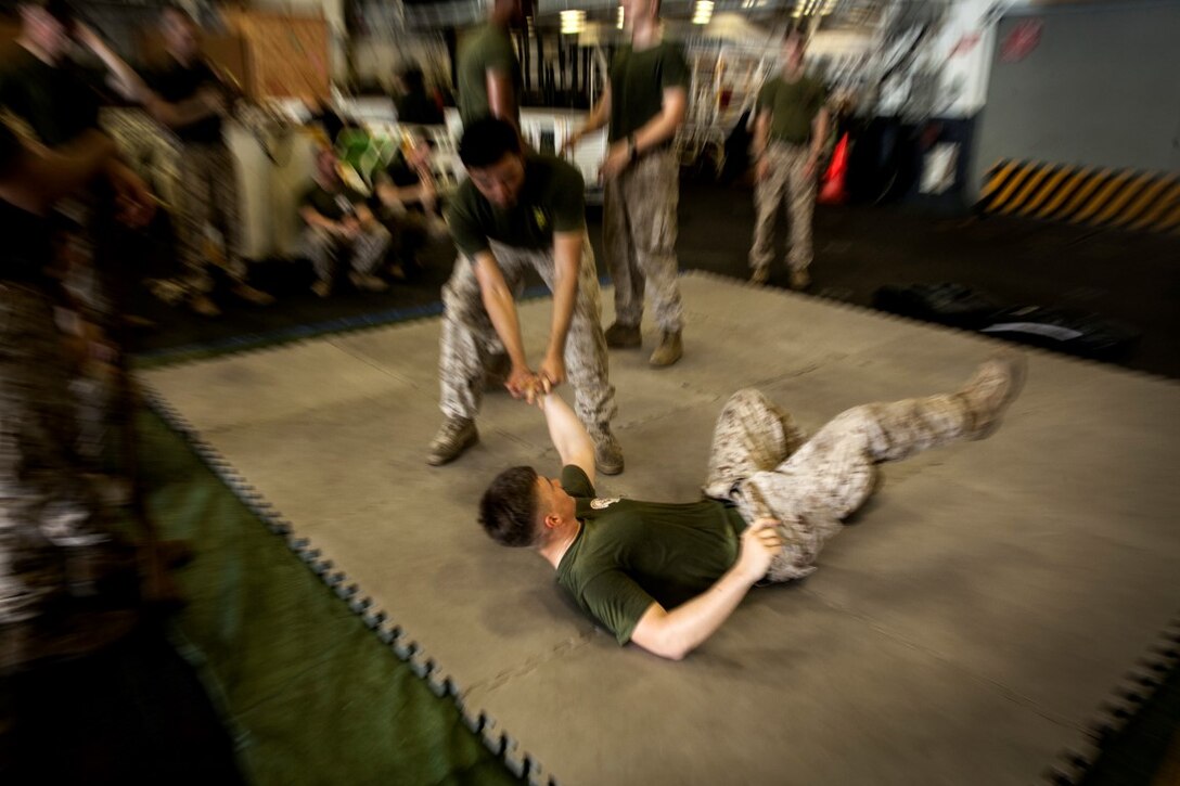 ARABIAN GULF (Sept. 18, 2015) A U.S. Marine with Lima Company, Battalion Landing Team 3rd Battalion, 1st Marine Regiment, 15th Marine Expeditionary Unit,  performs a wrist take down technique during a Marine Corps Martial Arts Program course in the hangar bay of the amphibious assault ship USS Essex (LHD 2). MCMAP teaches Marines hand-to-hand skills that might help in a combat situation. The 15th MEU, embarked aboard the ships of the Essex Amphibious Ready Group, is deployed to maintain regional security in the U.S. 5th Fleet area of operations. (U.S. Marine Corps photo by Cpl. Elize McKelvey/Released)