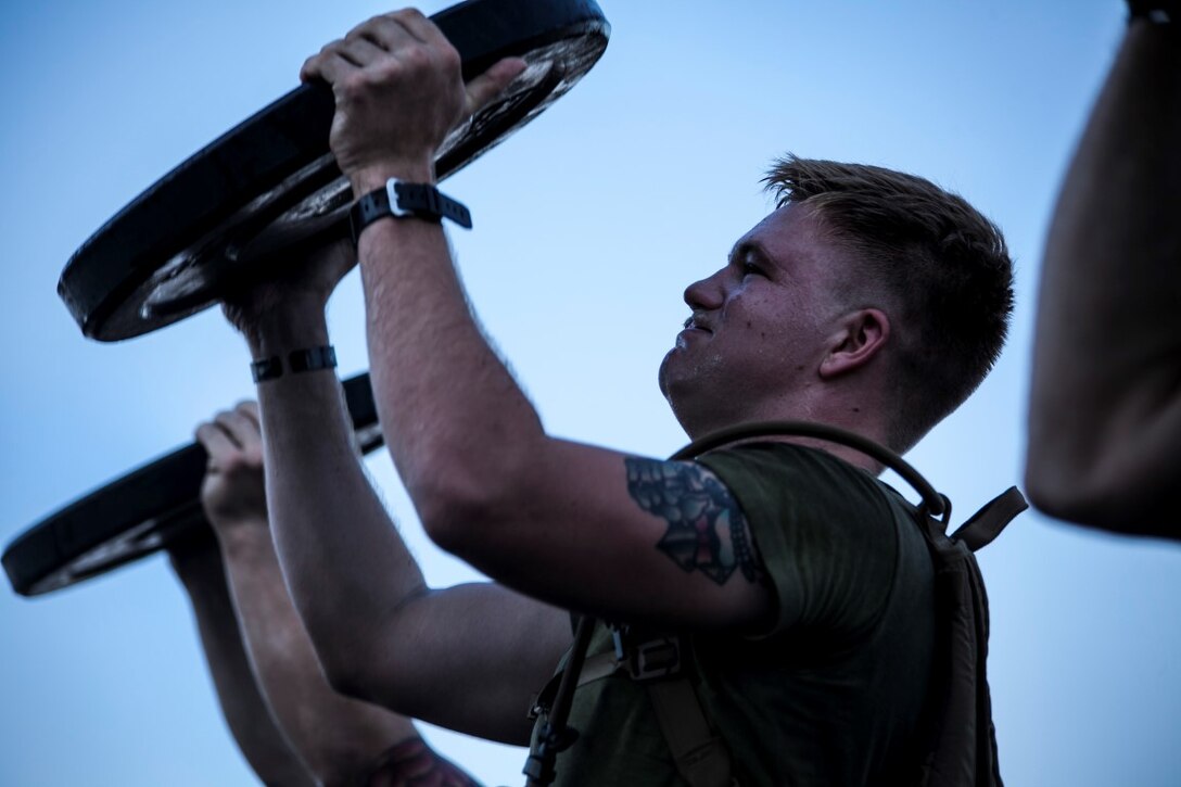 ARABIAN GULF (Sept. 22, 2015)  A U.S. Marine with the 15th Marine Expeditionary Unit lifts weights during physical training on the flight deck of the amphibious assault ship USS Essex (LHD 2). The Marines are attending a corporals course which prepares them to be successful noncommissioned officers. The 15th MEU, embarked aboard the ships of the Essex Amphibious Ready Group, is deployed to maintain regional security in the U.S. 5th Fleet area of operations. (U.S. Marine Corps photo by Cpl. Elize McKelvey/Released)