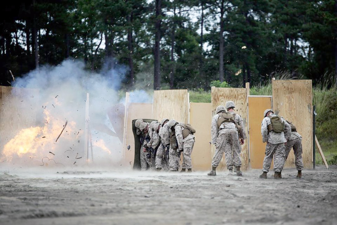 Marines take cover behind a shielding blanket as a charge detonates during a demolitions exercise on Camp Lejeune, N.C., Sept. 22, 2015. The Marines are assigned to the 2nd Battalion, 2nd Marine Regiment. U.S. Marine Corps photo by Cpl. Alexander Mitchell