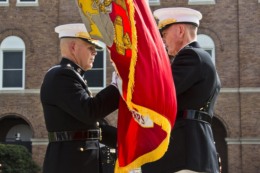 U.S. Marine Gen. Joseph F. Dunford, Jr., right, passes the Marine Corps colors to Gen. Robert B. Neller, left, at Marine Barracks Washington, D.C., Sept. 24, 2015. Neller took command from Dunford as the 37th Commandant of the Marine Corps. (U.S. Marine Corps photo by Sgt. Gabriela Garcia/Released)