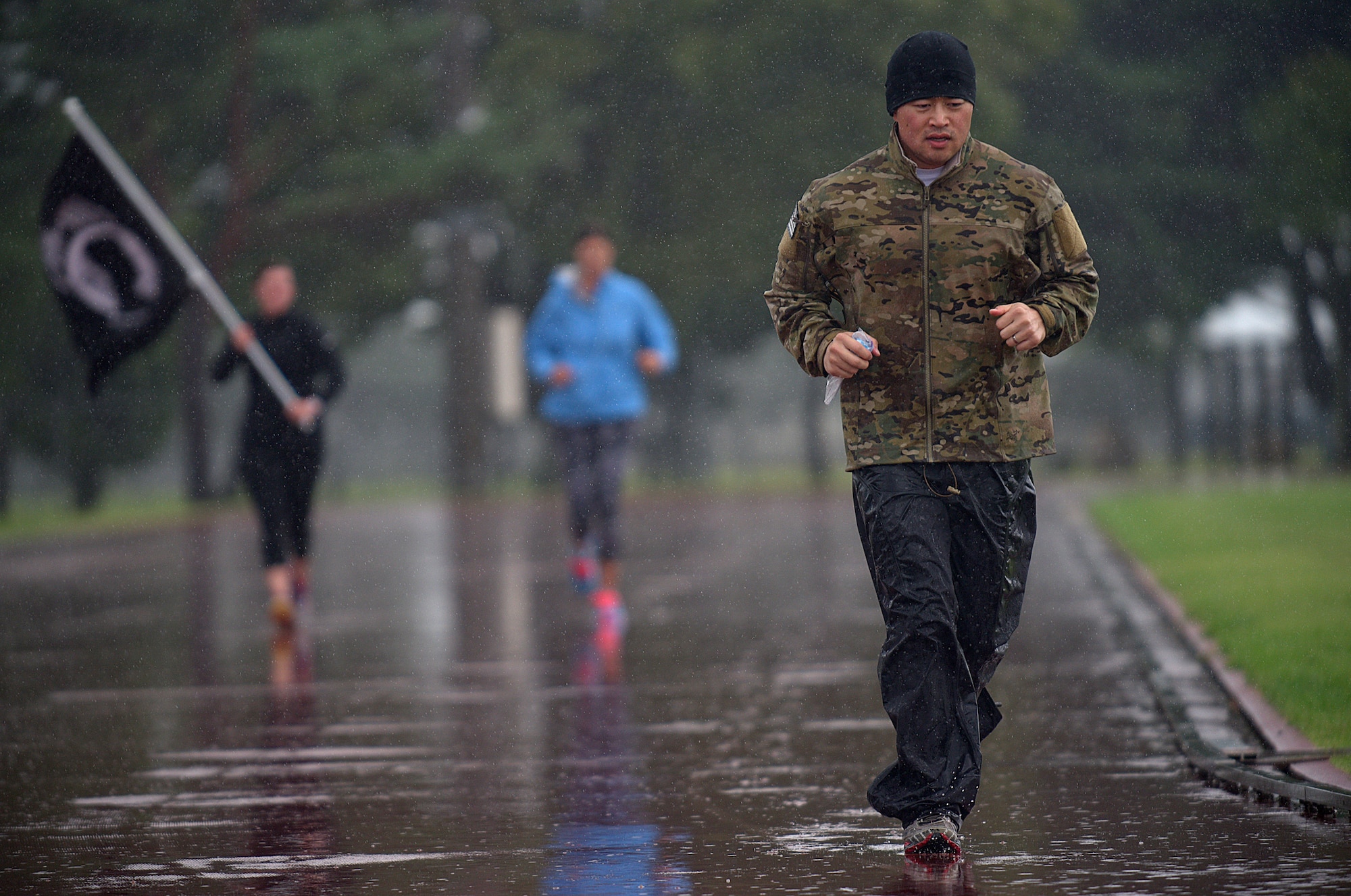 Capt. Michael Gruber, the 35th Communications Squadron director of operations, reaches his 65th mile while running in a downpour of rain Sept. 18, 2015, at Misawa Air Base, Japan. Beginning his ultramarathon at 5 p.m. on Sept. 17, 2015, Gruber’s goal was to run 100 miles in a span of 24 hours at the local high school track. (U.S. Air Force photo/Senior Airman Jose L. Hernandez-Domitilo)