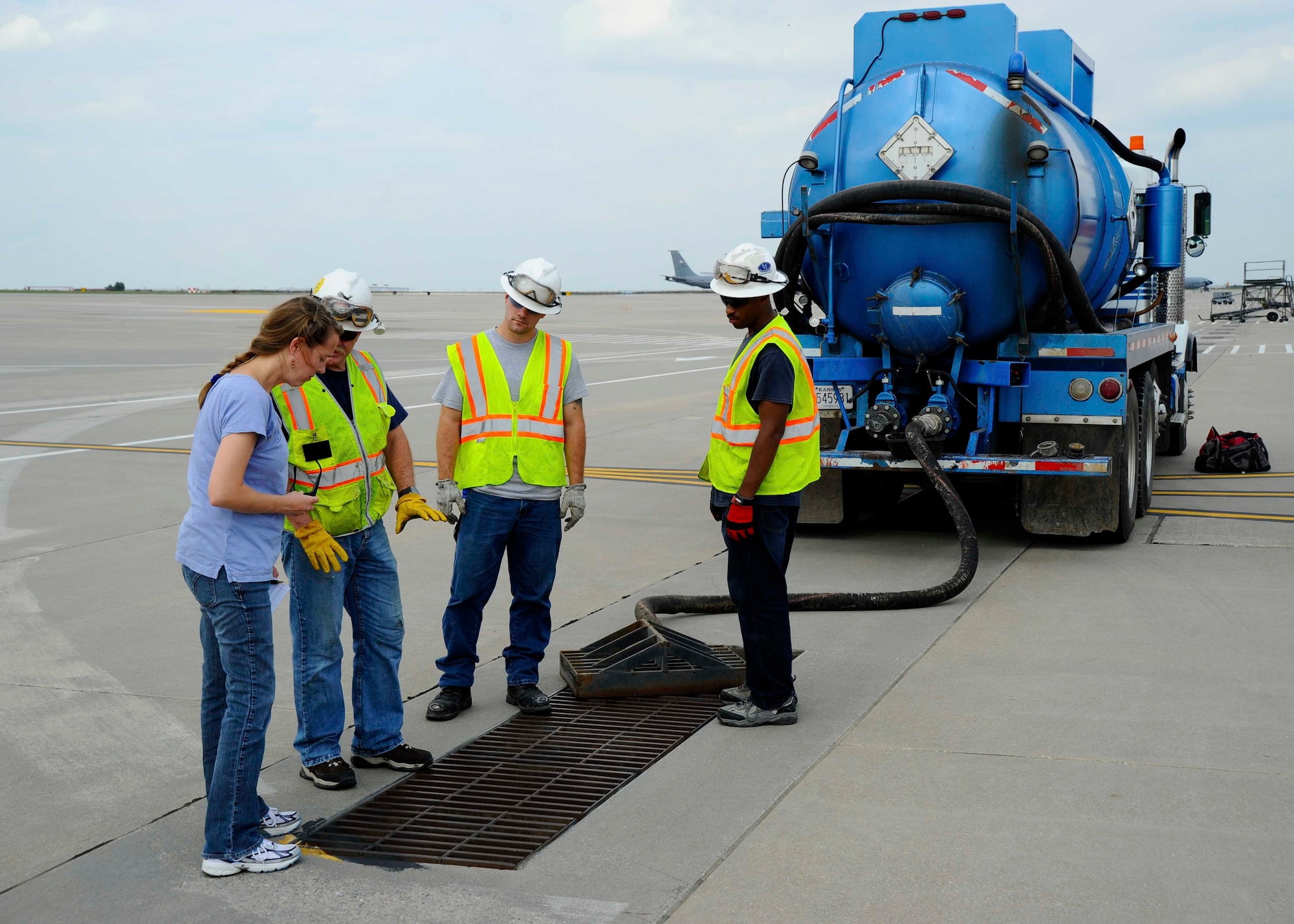 Kristi Draney, left, 22nd Civil Engineer Squadron environmental element chief, discusses the clean-up process of a fuel spill with three contractors, Sept. 25, 2015, at McConnell Air Force Base, Kan. Several hundred gallons of fuel leaked from a KC-135 Stratotanker the morning of the Sept. 25, and multiple agencies on McConnell and the local community worked together to quickly contain and start to clean the spill. (U.S. Air Force photo by Senior Airman Victor J. Caputo) 