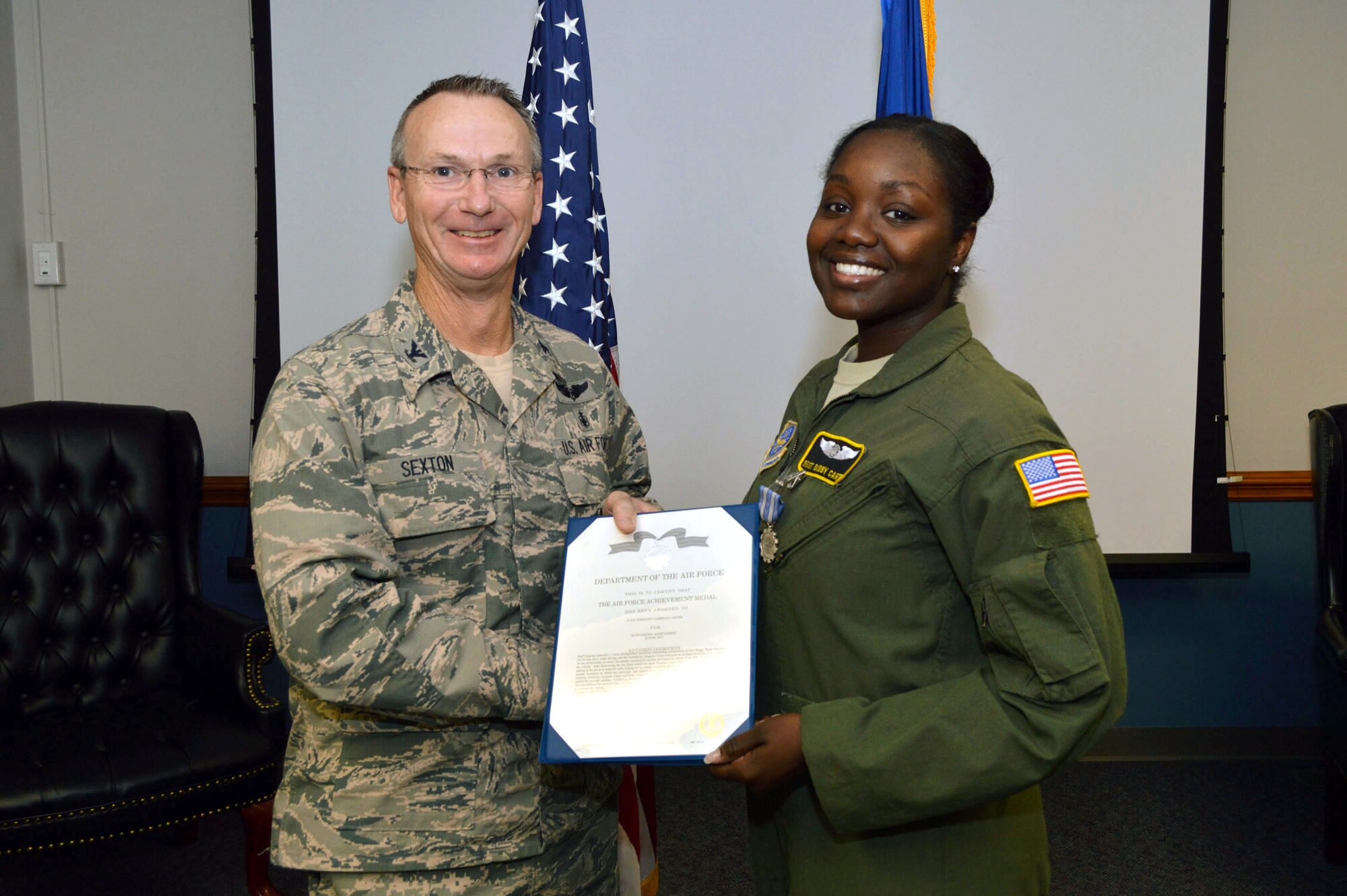 Col. Ricky Sexton, 43rd Aeromedical Evacuation Squadron commander, presents the Air Force Achievement Medal to Staff Sgt. Gabrielle Carter, an aeromedical evacuation technician assigned to the 43rd AES, Pope Army Airfield, North Carolina, on Sept. 17, recognizing her actions on June 25, 2015, by providing first aid to three victims involved in a multiple vehicle accident at Fort Bragg’s Reilly Road Gate. (U.S. Air Force photo/Marvin Krause)