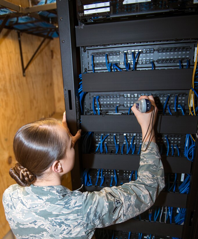 U.S. Air Force Airman Katlynn Ashby, 23d Communications Squadron network infrastructure technician, places an inductive amplifier into ports to locate a signal to identify network access Sept. 23, 2015, at Moody Air Force Base, Ga. The Network Control Center provides service for over 5,500 clients on base by managing approximately 7,000 computers and 1,500 switches, servers, and routers. (U.S. Air Force photo by Airman 1st Class Greg Nash/Released)