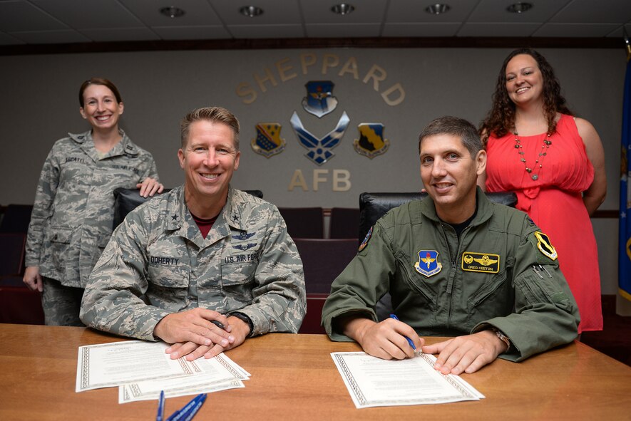 Brig. Gen. Patrick Doherty, 82nd Training Wing commander, and Col. Gregory Keeton, 80th Flying Training Wing commander, along with Capt. Kathryn Escatel and Tiffany Esparza from Sheppard Family Advocacy, sign the Oct. 2015 Domestic Violence Awareness Month Proclamation at Sheppard Air Force Base, Texas, Sept. 25, 2015. This year’s message is “healthy relationships are safe, respectful and positive.” (U.S. Air Force photo/Senior Airman Kyle Gese)