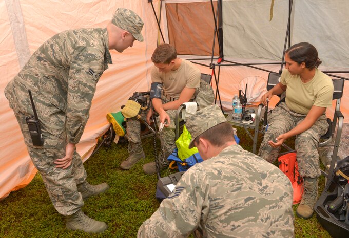 Staff Sgt. Matthew Calloway and A1C Corey Dedman, 628th Civil Engineering Squadron fire protection members, check the vital signs of SrA Brandon Lane, 628th Medical Group bio-environmental technician and A1C Vanessa Ramos, 628th Civil Engineering Squadron emergency management operator, at Joint Base Charleston – Air Base, S.C., Sept. 25, 2015.  Lane and Ramos are required to have their vital signs checked prior to donning their hazardous material suits. (U.S. Air Force photo/Airman 1st Class Thomas T. Charlton)