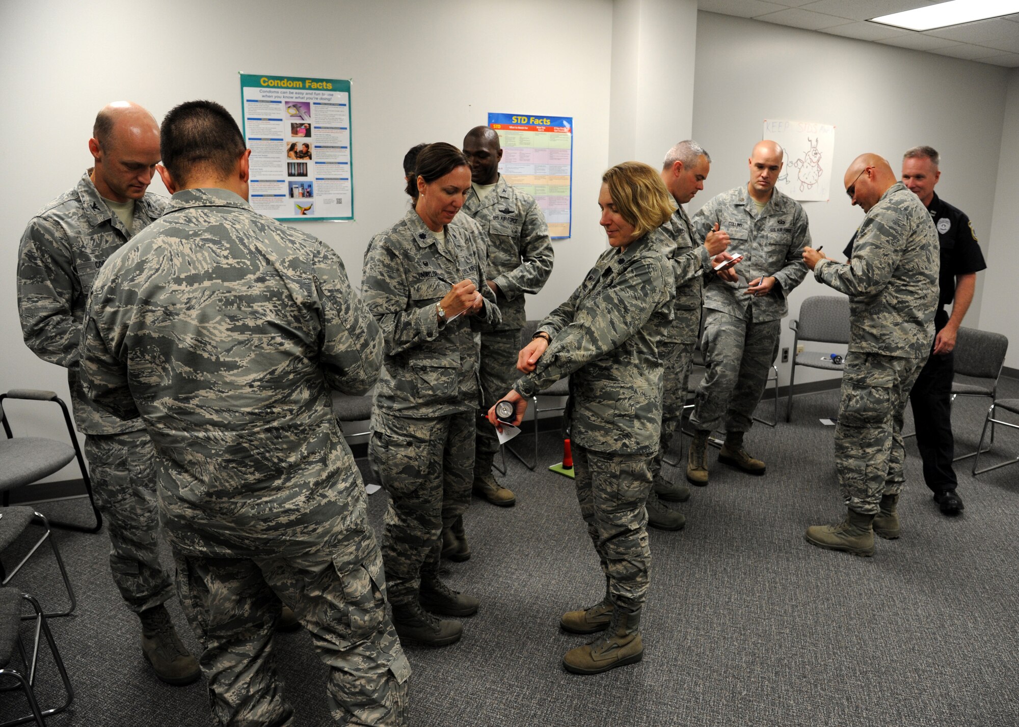 Leadership from the 319th Air Base Wing participaye in an activity in the Tunnel of Oppression Sept. 24, 2015, on Grand Forks Air Force Base, North Dakota. The Tunnel covers many issues that affect Airmen on a daily basis. The exercise was meant to show how easily sexually transmitted diseases can be spread. (U.S. Air Force photo by Airman 1st Class Ryan Sparks/Released)