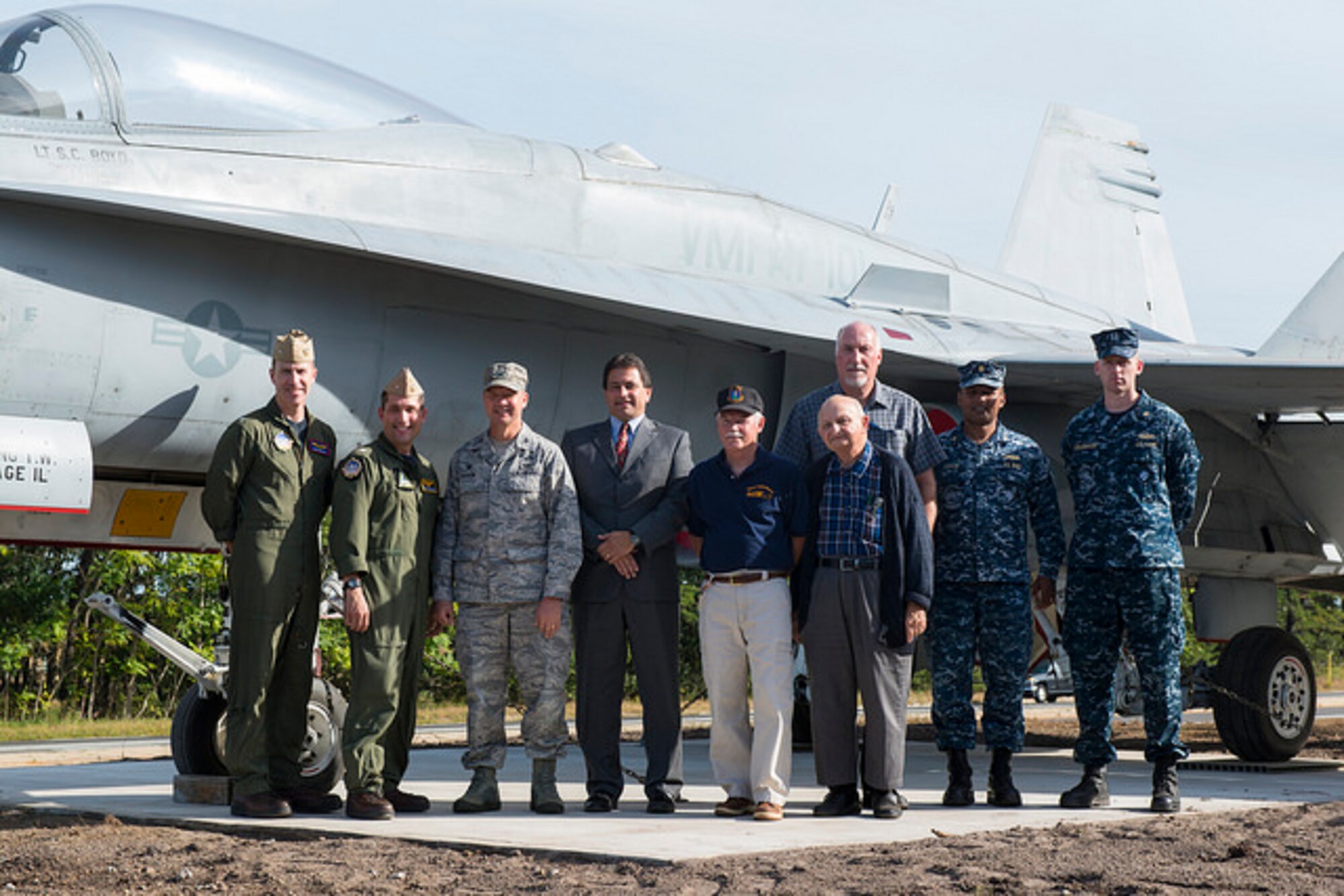 Joint base leaders pose in front of a new static display that welcomes military members and visitors to the Lakehurst Gate of Joint Base McGuire-Dix-Lakehurst, N.J. Sept. 24, 2015. The F-18C Hornet replaces the Blue Angel F-11 Tiger that was in place for nearly four decades. The Tiger will be restored and displayed on another part of the base when completed. (U.S. Air Force photo by Airman 1st Class Joshua King)