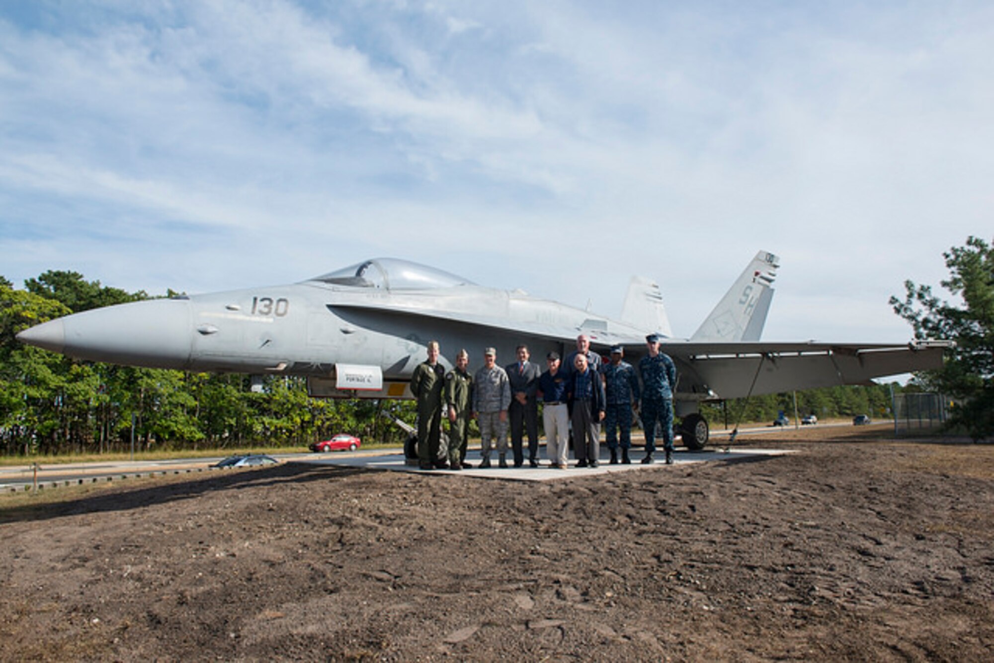 Joint base leaders pose in front of a new static display that welcomes military members and visitors to the Lakehurst Gate of Joint Base McGuire-Dix-Lakehurst, N.J. Sept. 24, 2015. The F-18C Hornet replaces the Blue Angel F-11 Tiger that was in place for nearly four decades. The Tiger will be restored and displayed on another part of the base when completed. (U.S. Air Force photo by Airman 1st Class Joshua King)