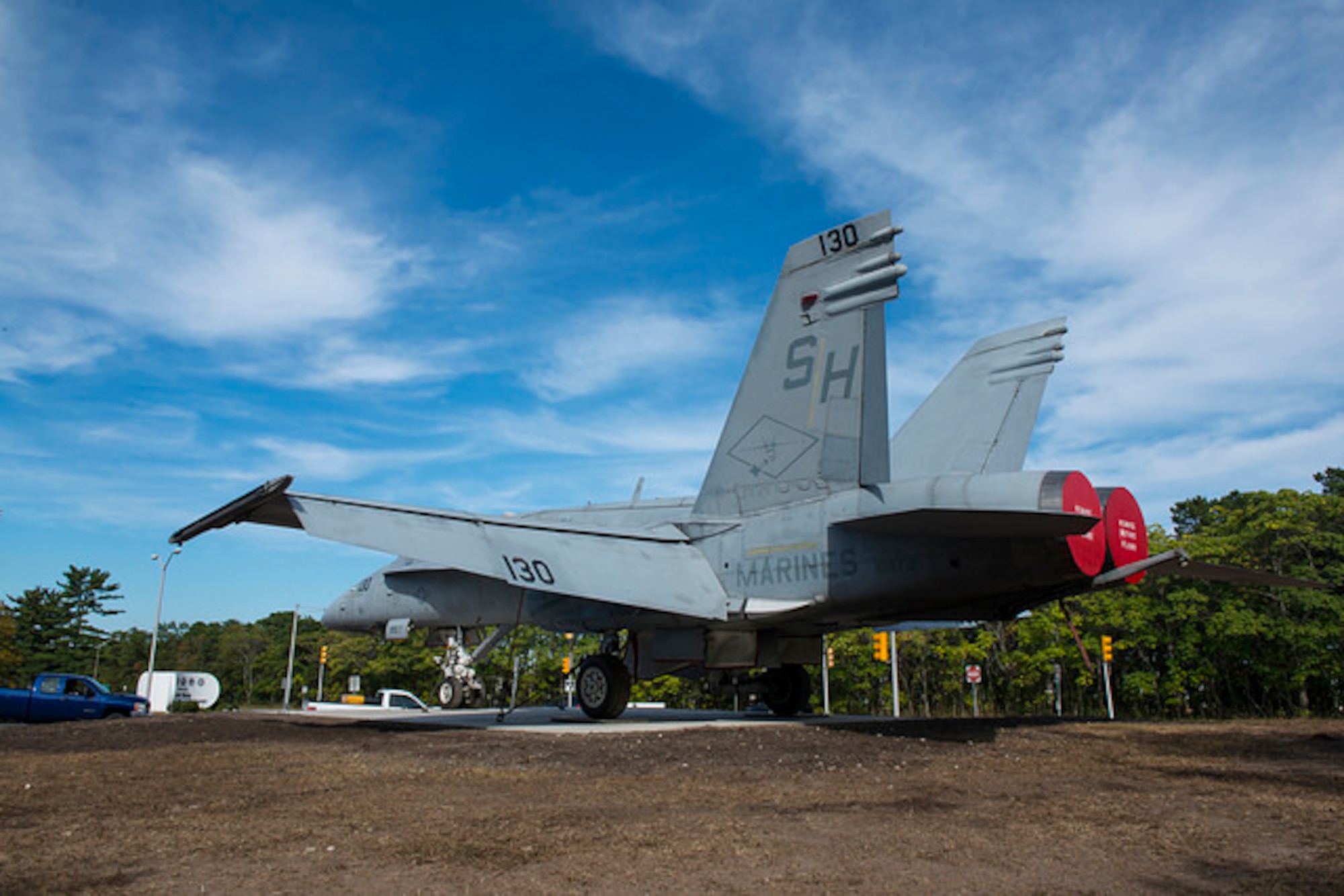 Joint base leaders pose in front of a new static display that welcomes military members and visitors to the Lakehurst Gate of Joint Base McGuire-Dix-Lakehurst, N.J. Sept. 24, 2015. The F-18C Hornet replaces the Blue Angel F-11 Tiger that was in place for nearly four decades. The Tiger will be restored and displayed on another part of the base when completed. (U.S. Air Force photo by Airman 1st Class Joshua King)