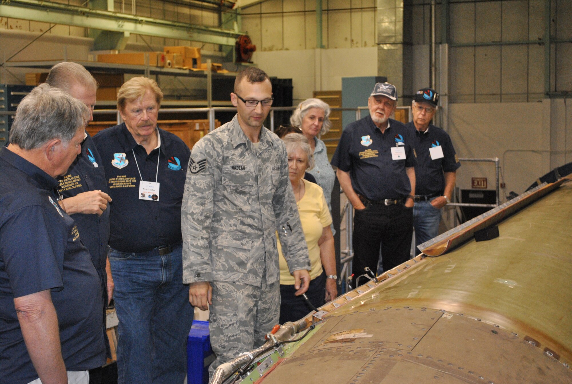 Staff Sgt. Nathan Nadeau, 576th Flight Test Squadron, shows members of the 51st Munitions Maintenance reunion group the Minuteman III downstage trainer in the 576 FLTS Missile Processing Facility. (U.S. Air Force Photo by 2nd Lt. Drake Cales/Released)