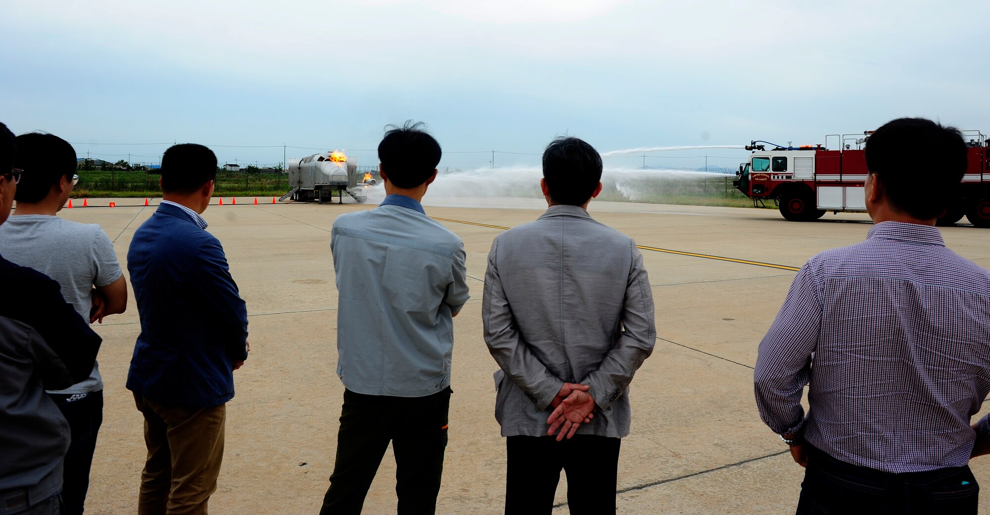 Members of the Gunsan City fire department receive a demonstration of a live aircraft fire trainer by the 8th Civil Engineer Squadron fire department at Kunsan Air Base, Republic of Korea, Sept. 16, 2015. In addition to the live aircraft fire trainer, the Gunsan City firefighters were able to see vehicles, tools and equipment they have not seen before. (U.S. Air Force photo by Staff Sgt. Nick Wilson/Released)