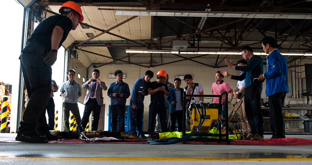 Members of the Gunsan City fire department receive a demonstration of various tools used by the 8th Civil Engineer Squadron fire department at Kunsan Air Base, Republic of Korea, Sept. 16, 2015. Members of the Gunsan City fire department visited the fire department to get a tour of the building, meet the Airmen and learn about their equipment. (U.S. Air Force photo by Staff Sgt. Nick Wilson/Released)