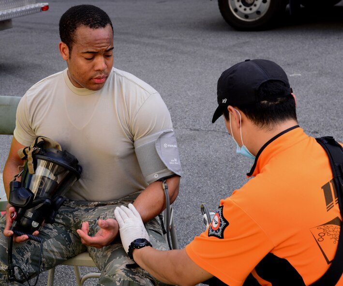 Senior Airman Paul Byous, 51st Civil Engineer Squadron firefighter, has his blood pressure checked by a Korean emergency medical technician Sept. 24, 2015, near Songtan, Republic of Korea. Byous and more than 25 other members of the 51st CES from Osan Air Base participated in a joint-training exercise involving a simulated hazardous materials spill. (U.S. Air Force photo by Staff Sgt. Benjamin Sutton)