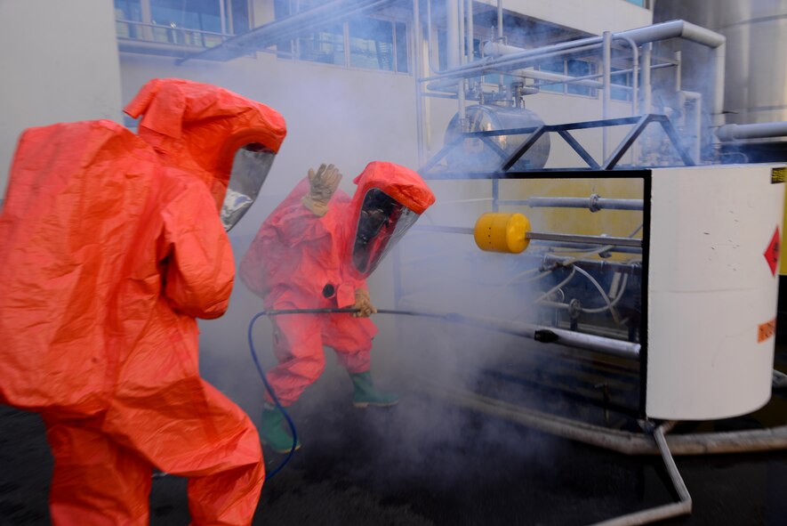 Two emergency first responders from the Songtan fire department plug a hole during a simulated hazardous material training event Sept. 24, 2015, near Songtan, Republic of Korea. The South Korean agencies invited members of Osan Air Base's 51st Civil Engineer Squadron to the unique training event. (U.S. Air Force photo by Staff Sgt. Benjamin Sutton)