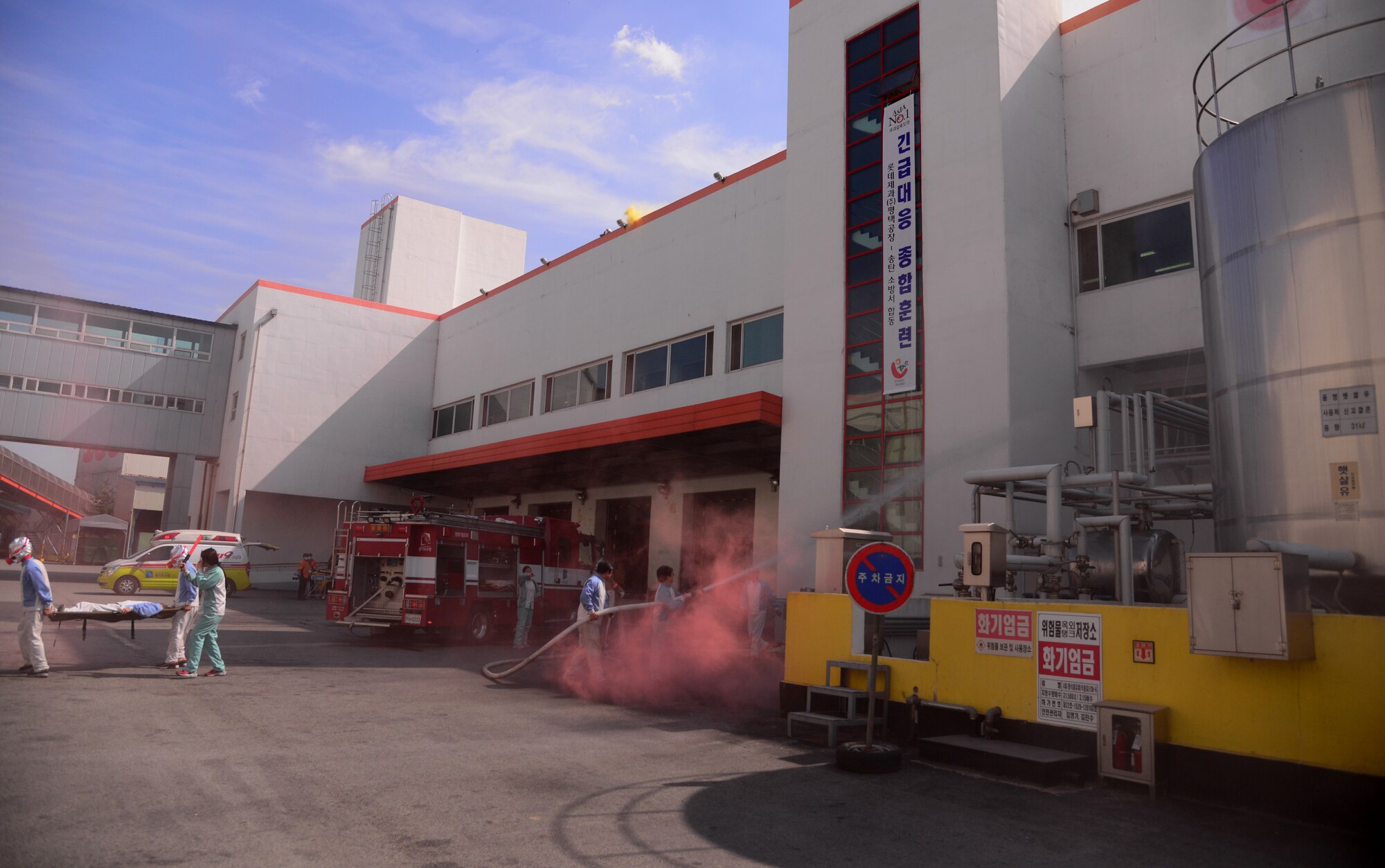 South Korean first-responders practice evacuation procedures while putting out a simulated factory fire Sept. 24, 2015, near Songtan, Republic of Korea. Members of the 51st Civil Engineer Squadron conducted a hazardous materials training session with the local emergency responders in order to practice joint-operations. (U.S. Air Force photo by Staff Sgt. Benjamin Sutton)