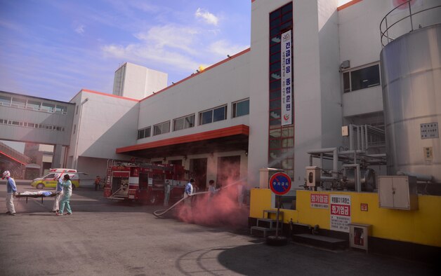 South Korean first-responders practice evacuation procedures while putting out a simulated factory fire Sept. 24, 2015, near Songtan, Republic of Korea. Members of the 51st Civil Engineer Squadron conducted a hazardous materials training session with the local emergency responders in order to practice joint-operations. (U.S. Air Force photo by Staff Sgt. Benjamin Sutton)