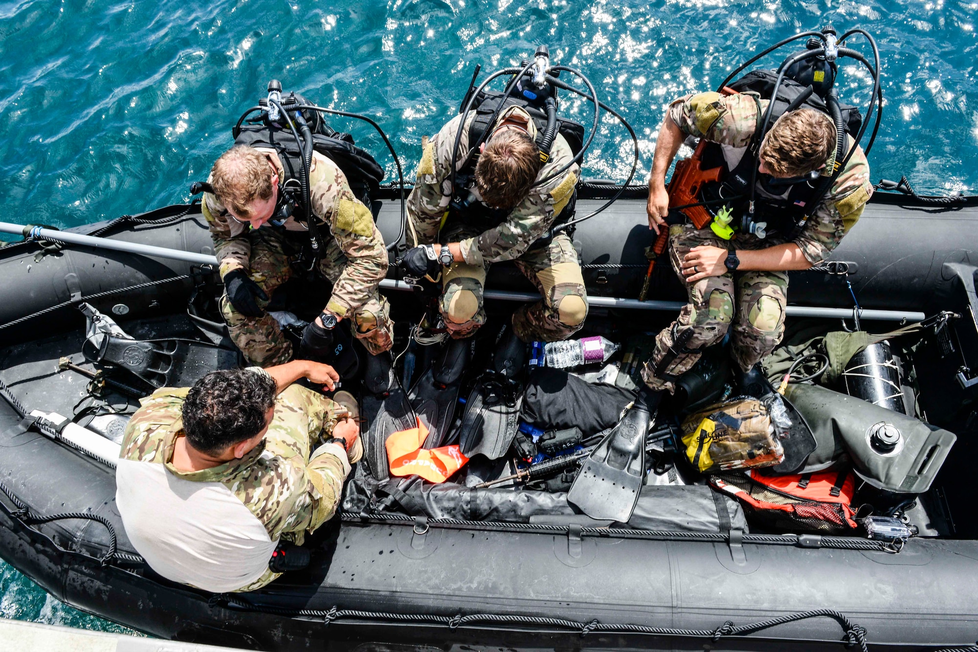 U.S. Air Force Airmen from the 320th Special Tactics Squadron, Kadena Air Base, ready their scuba diving gear during an amphibious operations exercise Sept. 22, 2015, off the west coast of Okinawa, Japan. Teamwork is vital to the successful and safe completion of special tactics objectives, especially in the face of adversities such as harsh weather conditions and terrain. (U.S. Air Force photo by Senior Airman John Linzmeier)