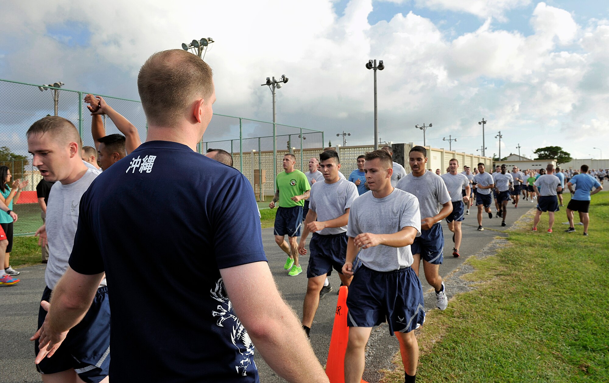 Kevin Ball, 18th Force Support Squadron Risner Fitness Center director, welcomes runners at the finish line Sept. 25, 2015, on Kadena Air Base, Japan. The event was coordinated as part of national suicide prevention awareness month to increase awareness of suicide prevention resources. (U.S. Air Force photo by Naoto Anazawa)