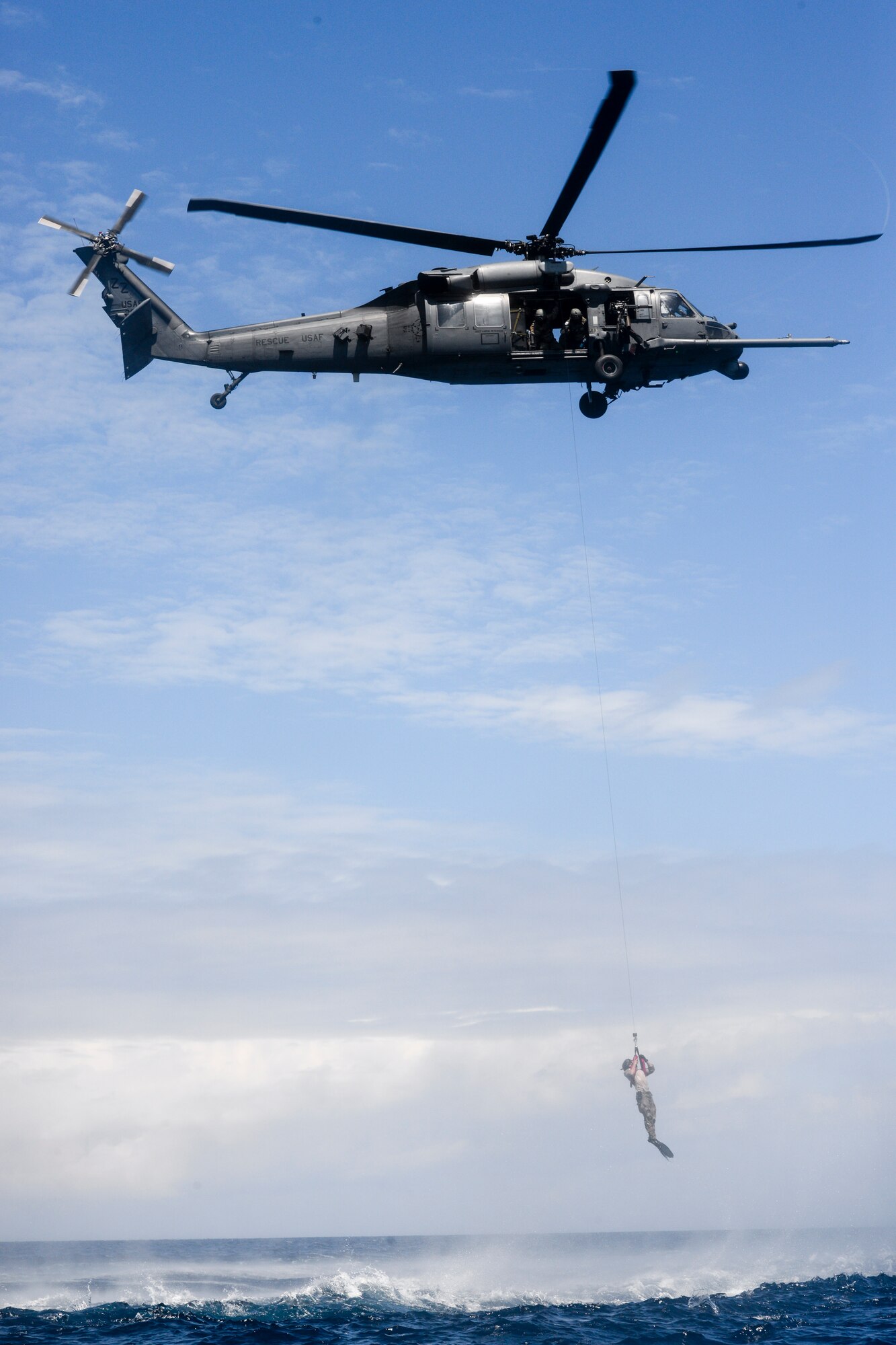 A U.S. Air Force HH-60G Pave Hawk from the 33rd Rescue Squadron, Kadena Air Base, performs a hoist recovery with an Airman from the 320th Special Tactics Squadron during an amphibious operations exercise Sept. 22, 2015, off the West Coast of Okinawa, Japan. Team members are qualified in non-standard methods of infiltration to include static line, military freefall and closed and open circuit diving. (U.S. Air Force photo by Senior Airman John Linzmeier)