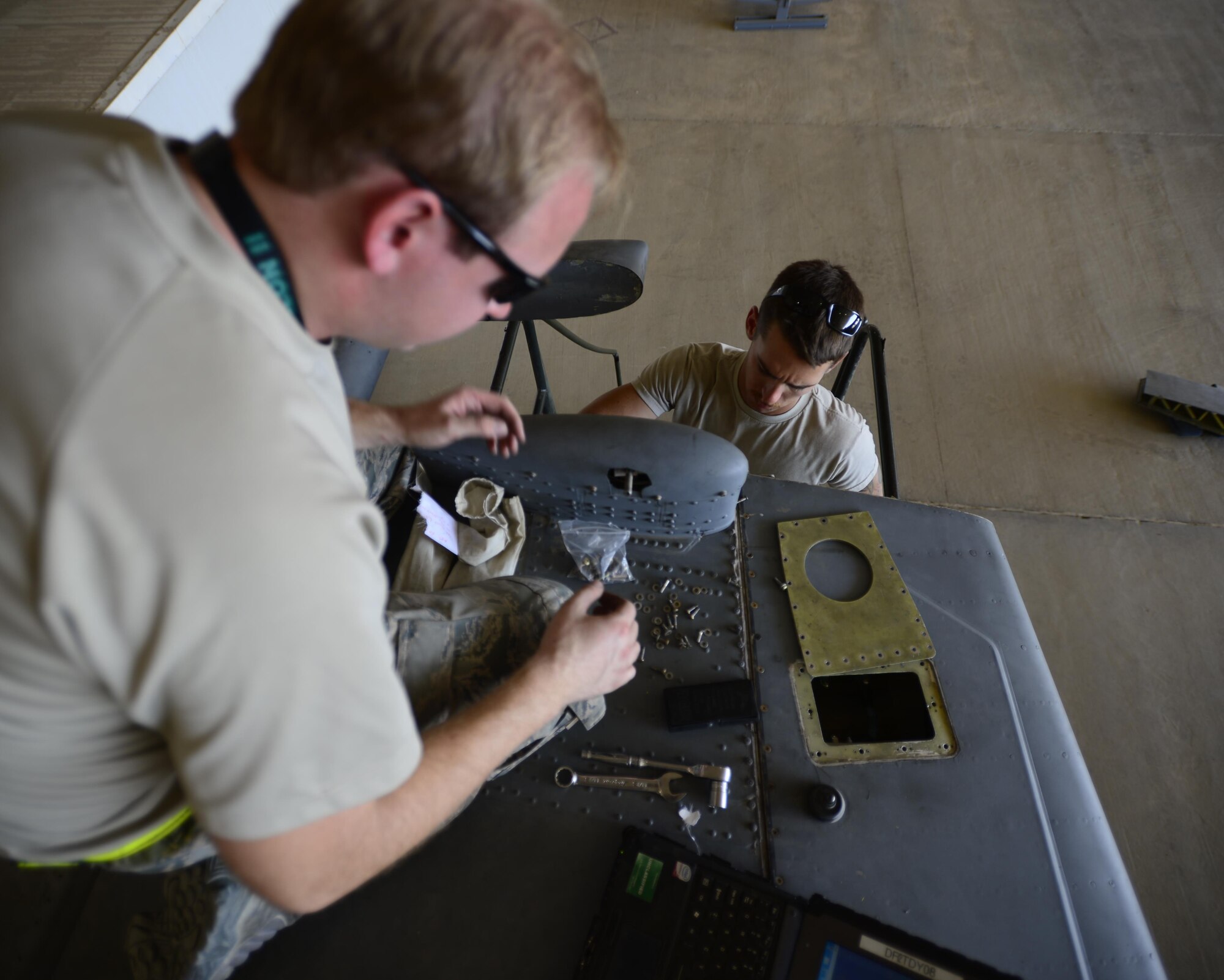 U.S. Air Force Staff Sgt. Sean Jones, 386th Expeditionary Aircraft Maintenance Squadron aerospace maintenance craftsman, sorts through parts for Senior Airman Christopher Lamb, 386th Expeditionary Aircraft Maintenance Squadron aerospace maintenance operator, at an undisclosed location in Southwest Asia, Sept. 25, 2015. After a home station inspection, EAMXS members changed a propeller on a C-130 Hercules aircraft to ensure mission effectiveness during Operation Inherent Resolve. (U.S. Air Force photo by Staff Sgt. Tyler Alexander/Released)